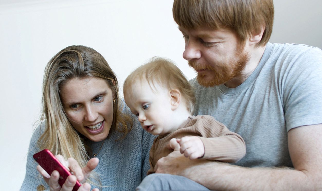 A joyful family bonding moment as they look at a smartphone
