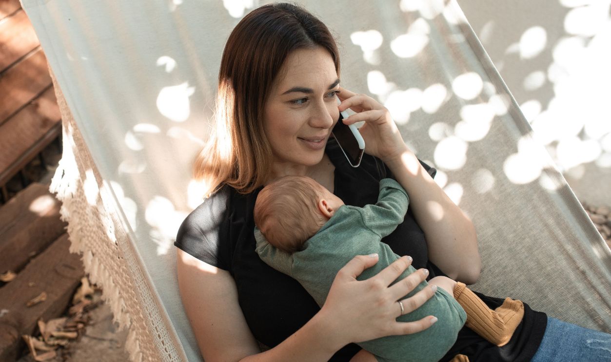 Mother talking on phone while holding baby