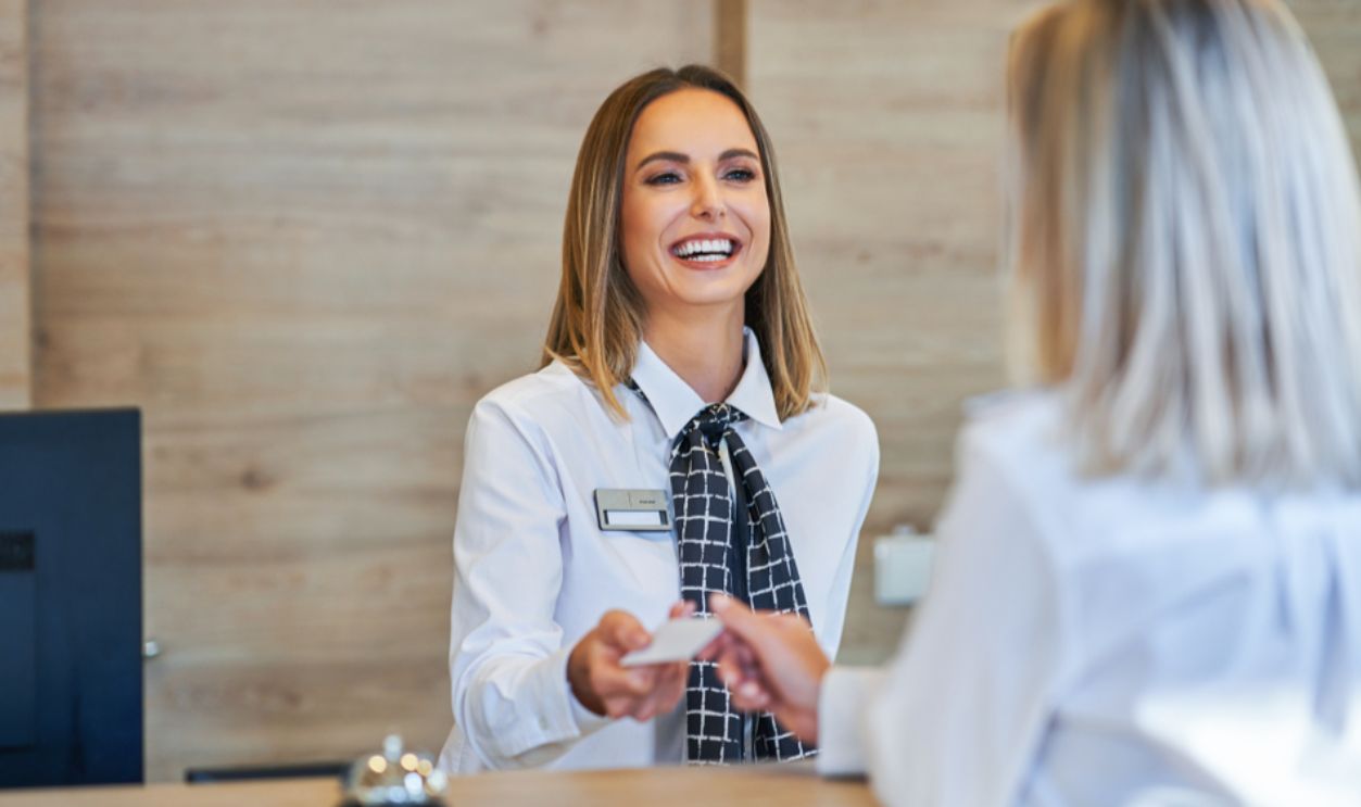 Receptionist and businesswoman at hotel front desk