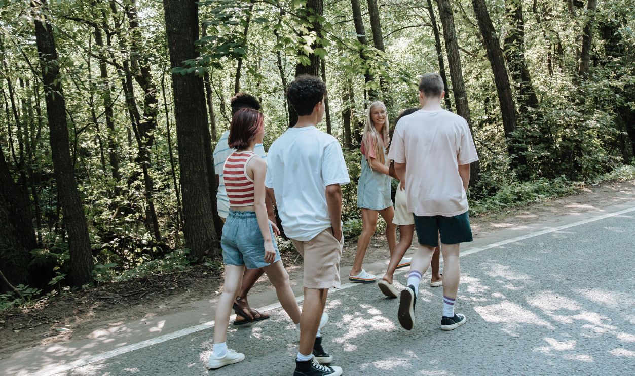 Group of teenagers walking together on a forest pathway