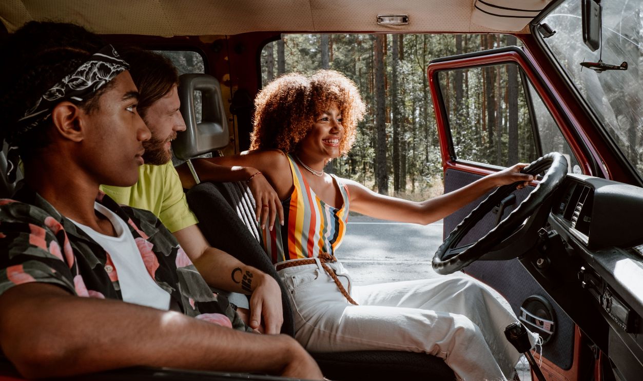 Young friends on a joyful summer road trip in a vintage car