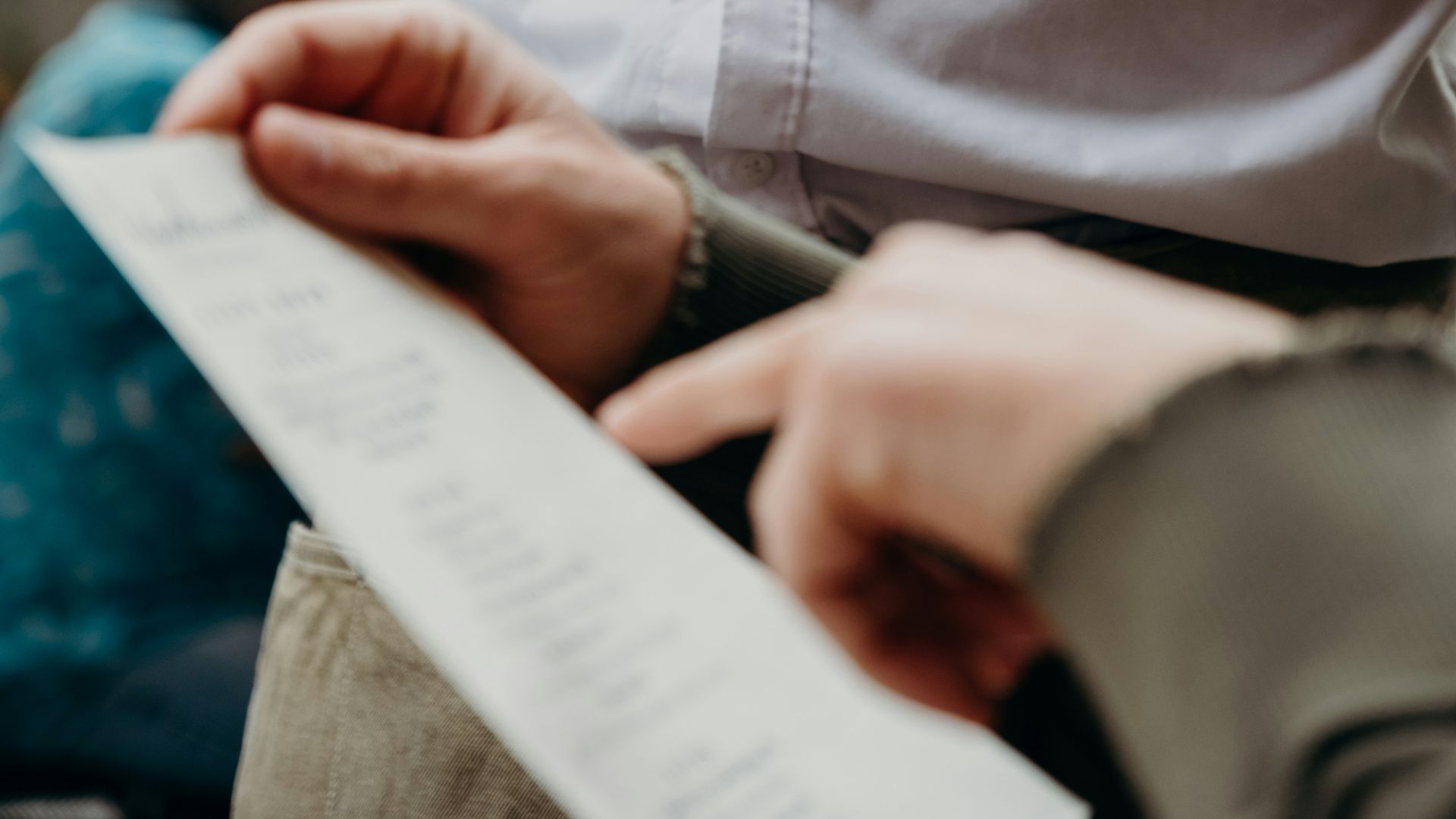 A person in a white shirt holding a notepad and a menu