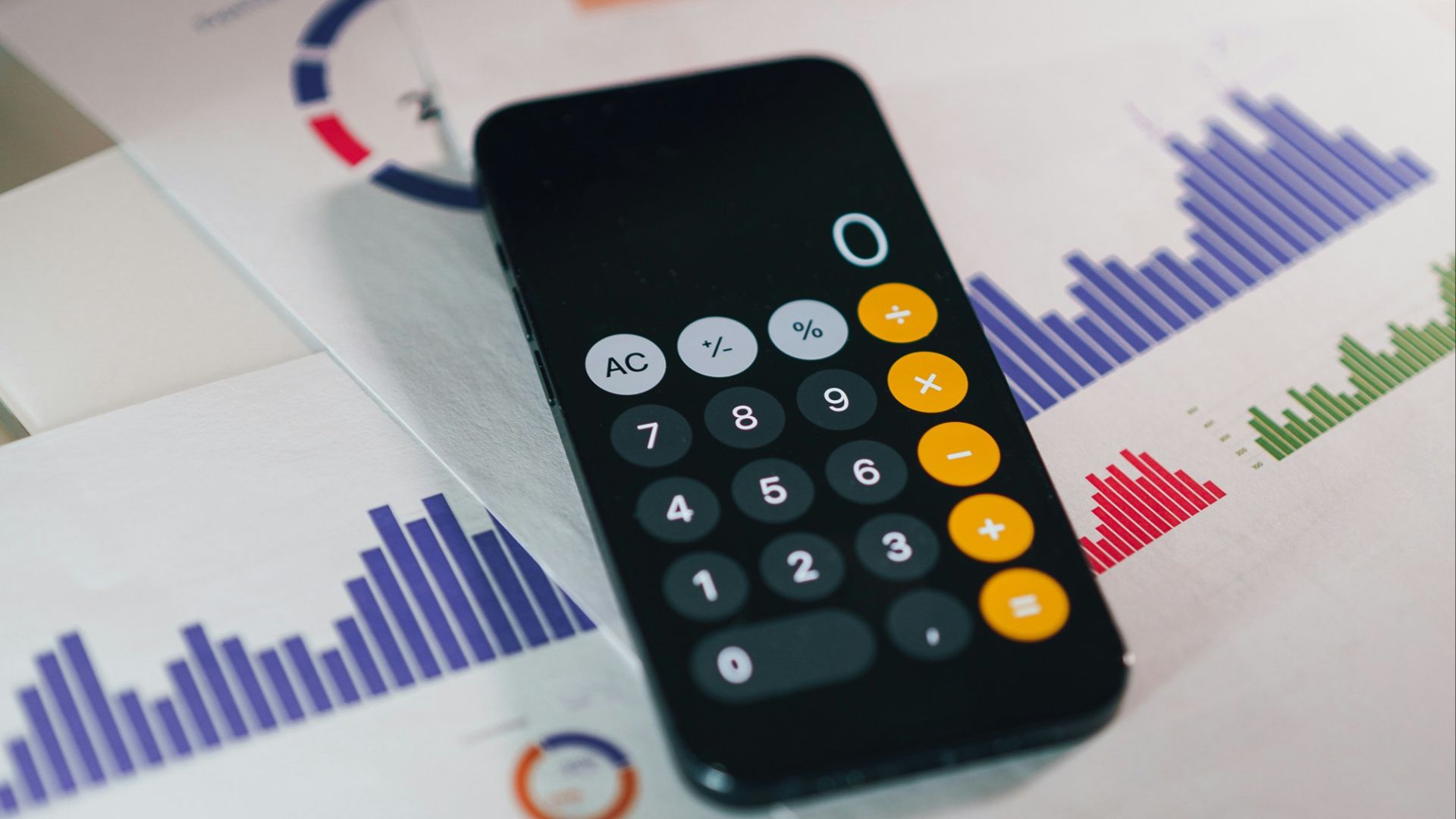 smartphone calculator app on financial report papers