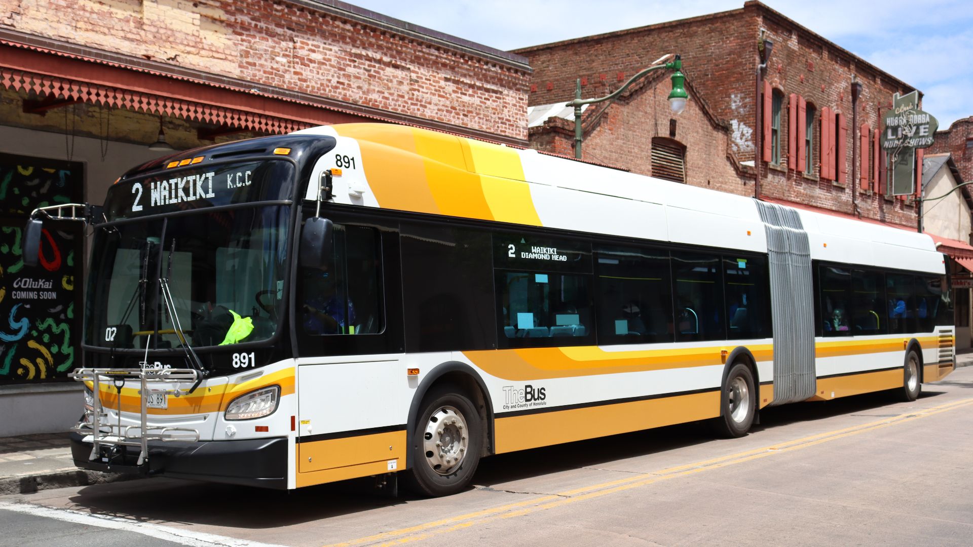 A TheBus New Flyer XDE60 on the Route 2 headed Diamond Head-bound (eastbound) on Hotel Street in Chinatown. The exterior signs are displaying the normal destination information, which alternates with the