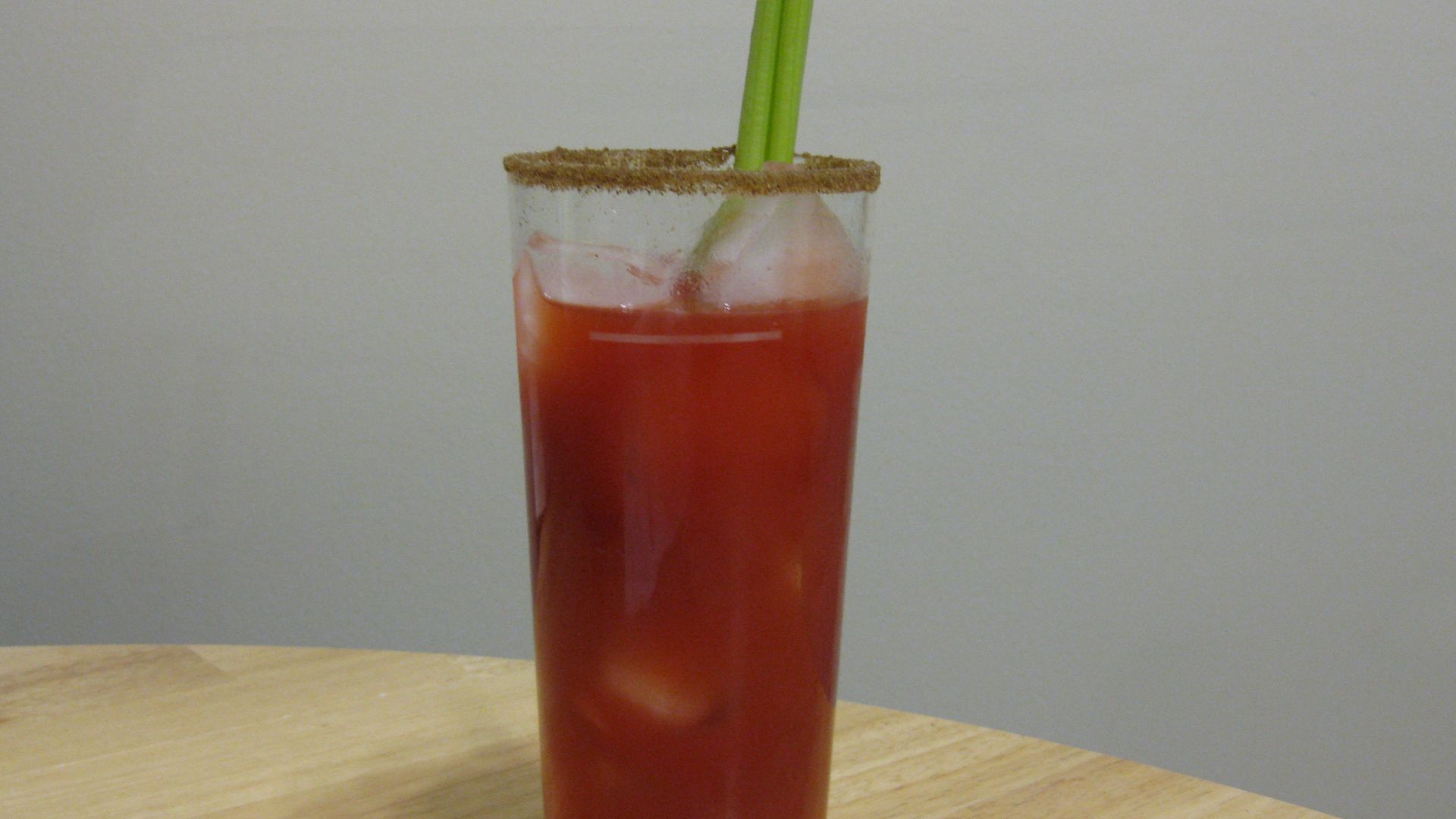 A Caesar cocktail made with Mott's Spicy Clamato Caesar (premixed bottle), celery, celery salt rim, and ice.