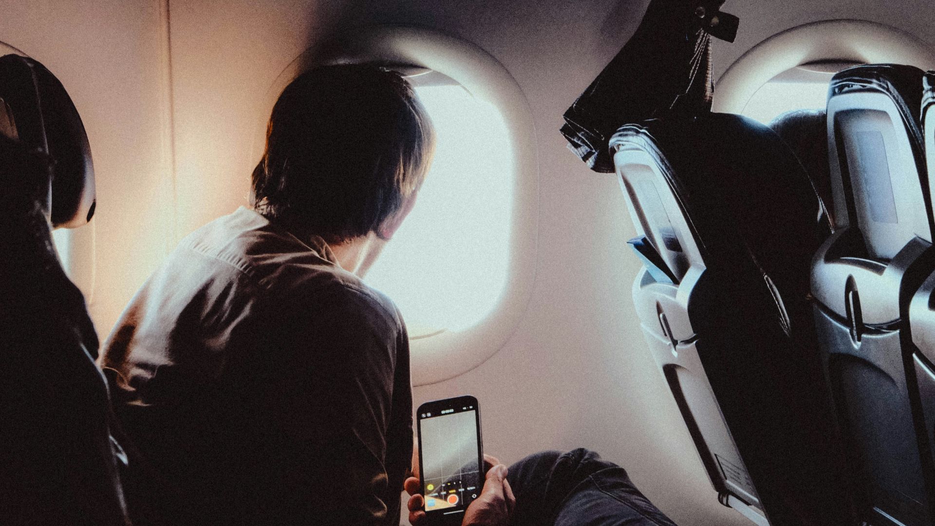 Passengers looking out airplane window during flight