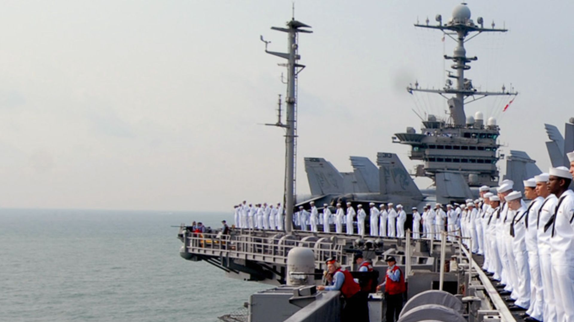 SINGAPORE (Aug. 2, 2009) Sailors man the rails aboard the aircraft carrier USS George Washington (CVN 73) while underway off the coast of Singapore. George Washington, the Navy's only permanently forward deployed aircraft carrier, is on a scheduled port v