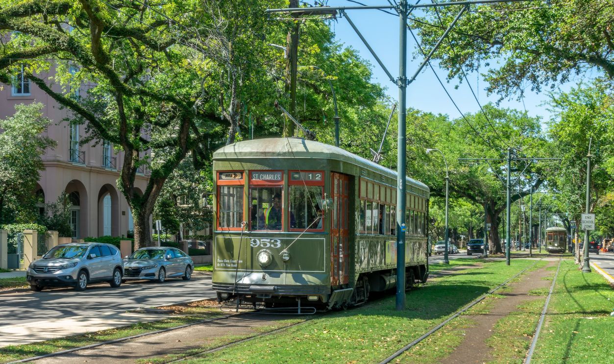 NEW ORLEANS, LOUISIANA - APRIL 8, 2025: Green streetcar and trees, St Charles line in the Garden district on April 8, 2025 in New Orleans, Lousiana 