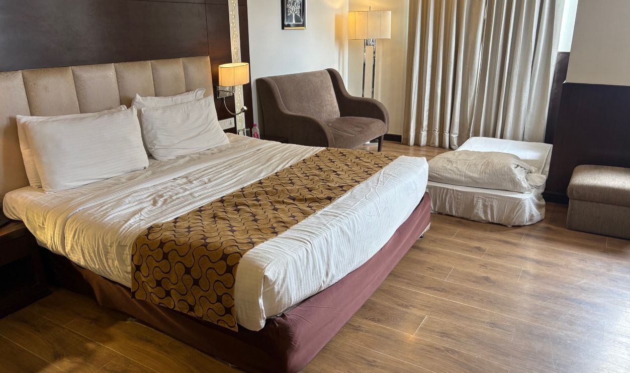 A chic hotel room featuring a comfortable bed, modern furniture, and soft lighting