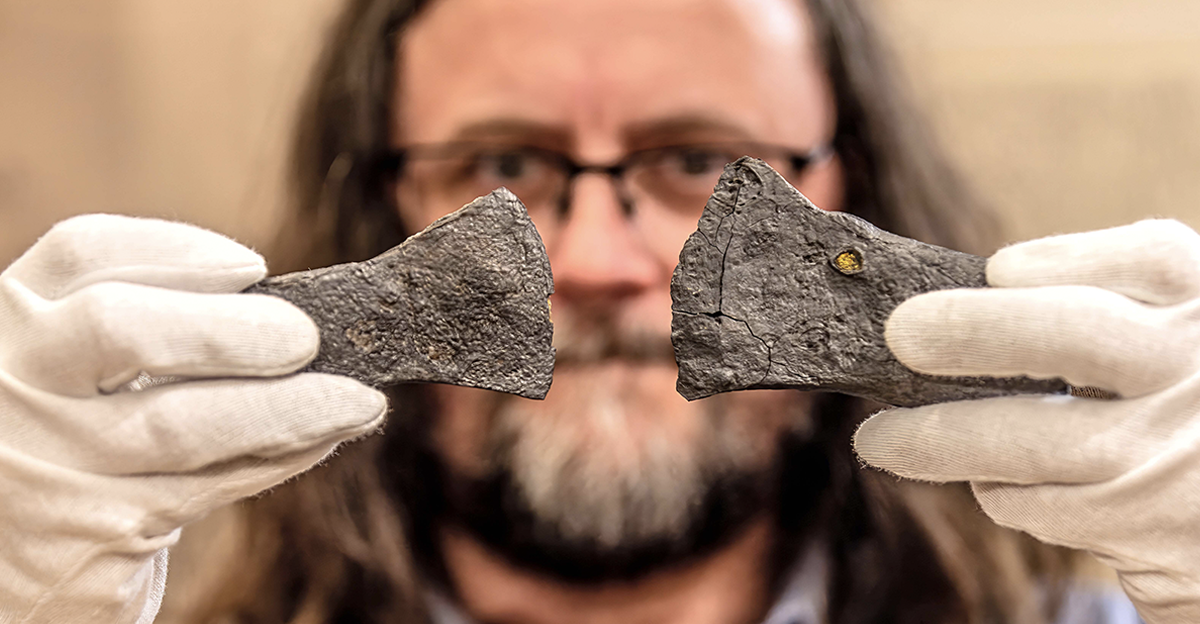 05 March 2026, North Rhine-Westphalia, Olsberg: Archaeologist Manuel Zeiler shows two iron axes from the Bruchhauser Stones.