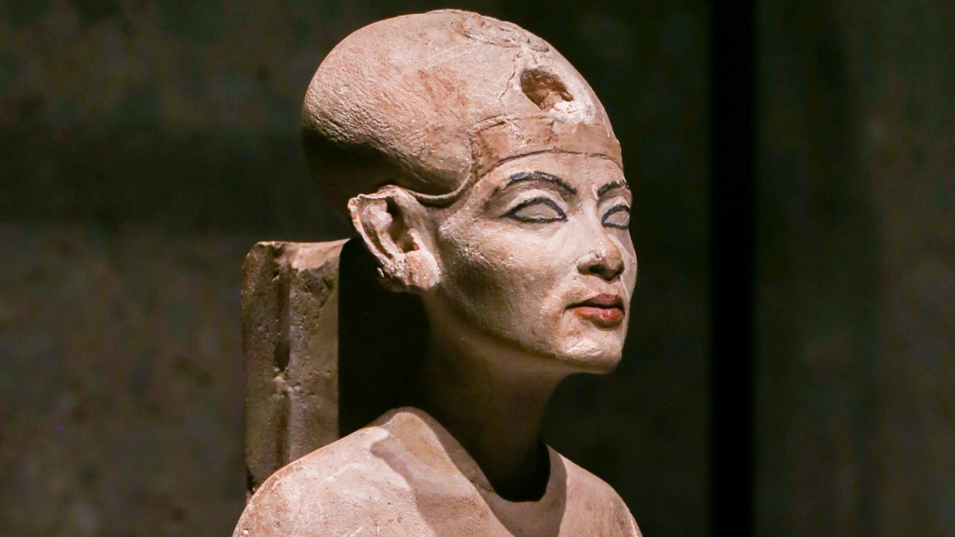 object type: portrait statuette
- description: Nefertiti / Nofretete standing, left leg advanced, wearing bonnet and crown, under the clothes the naturalistic depiction of the body forms shines through
- production place: Achet-Aton / Amarna
- artist / wo