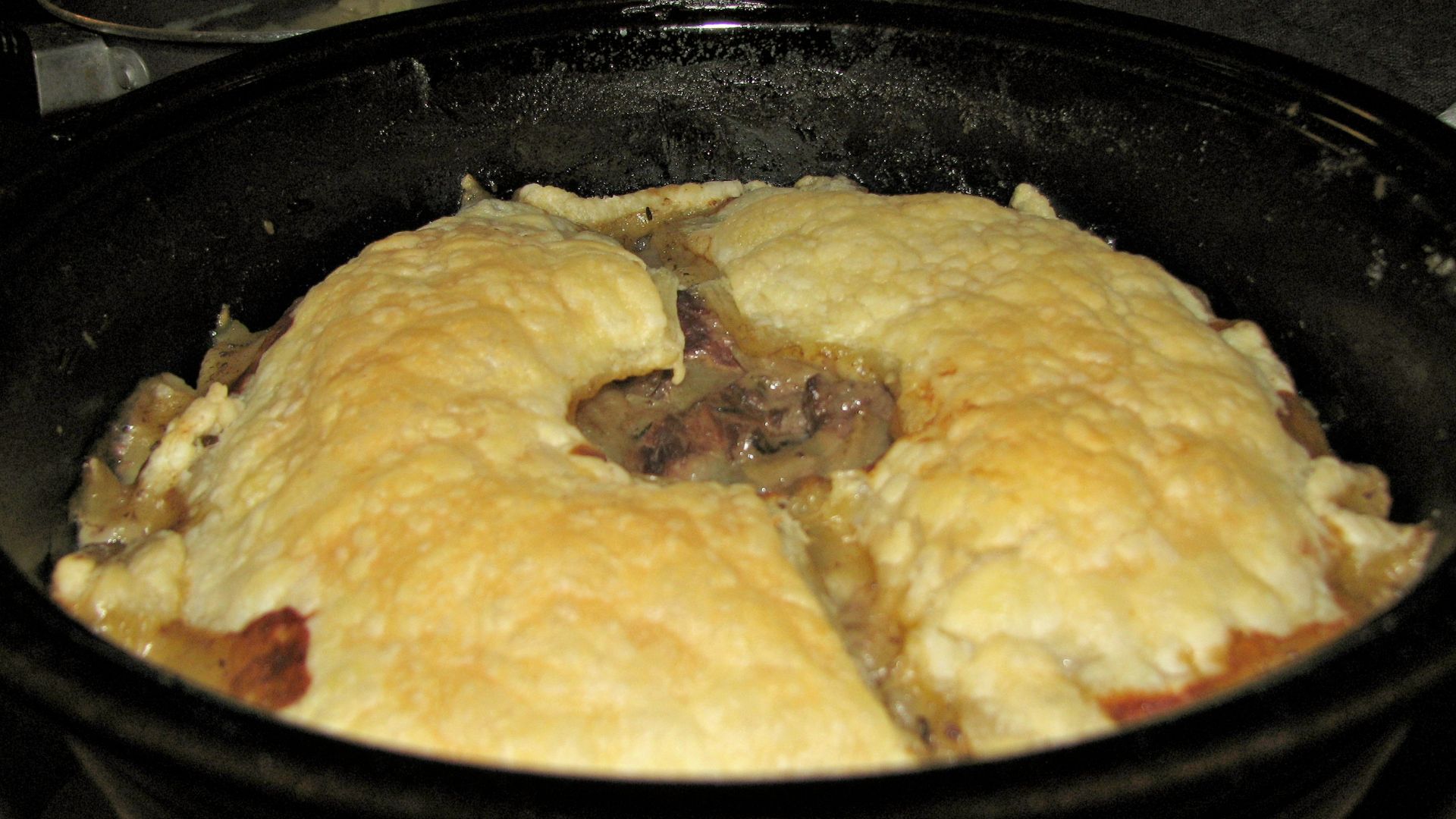 A small steak and kidney pie made as a one crust pie with puff pastry for a lid.