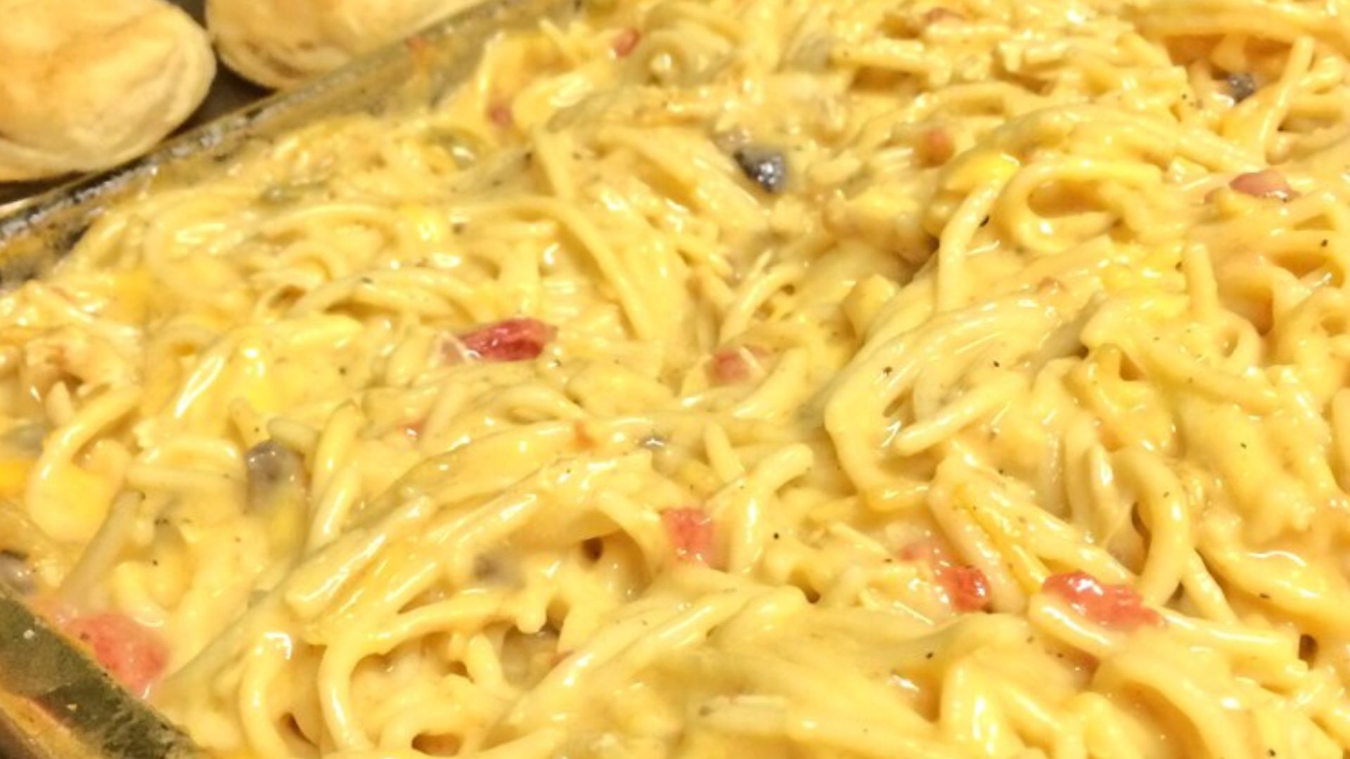 Chicken spaghetti made from velveta, canned rotel, and accompanied by biscuits.