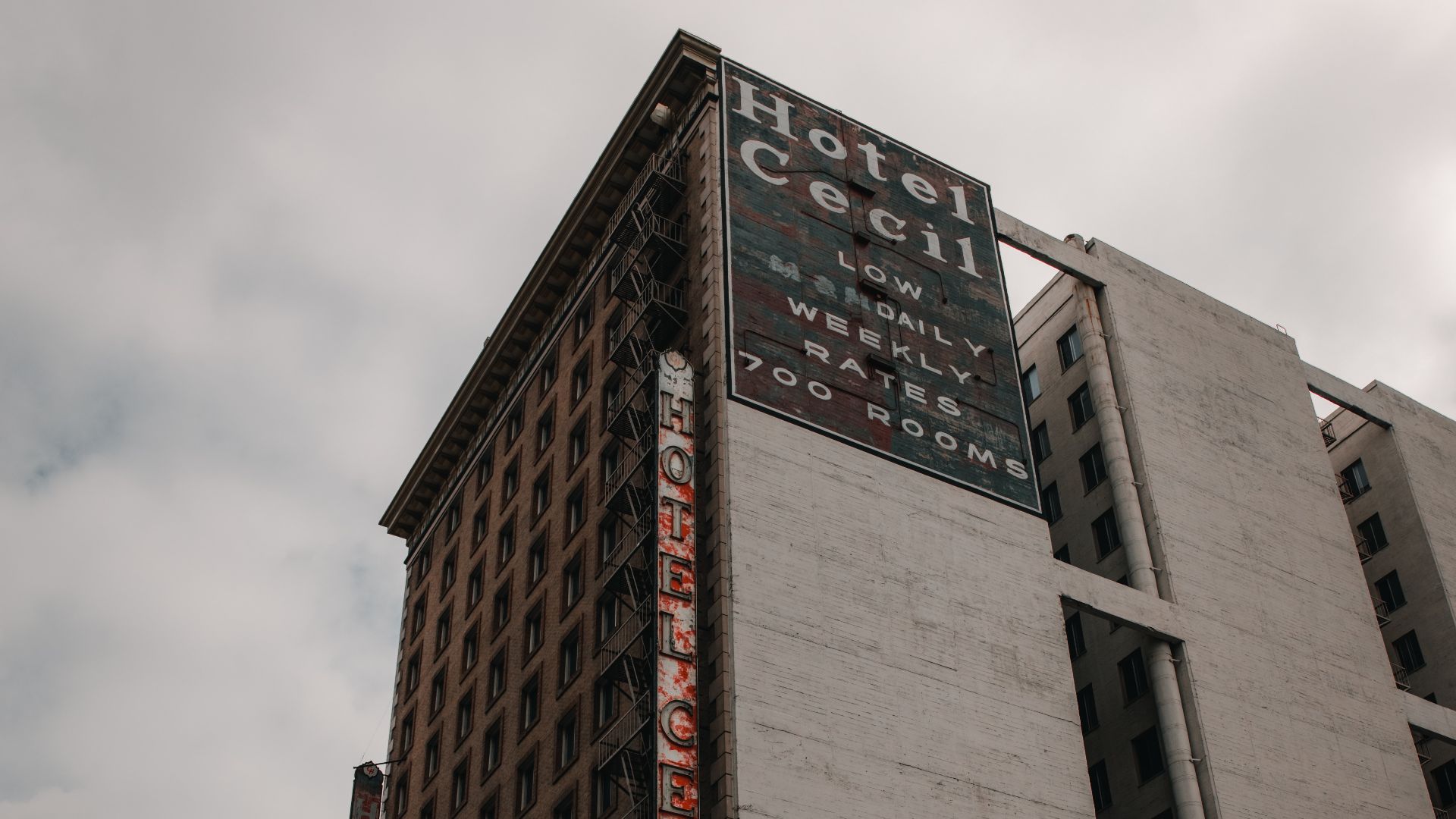 Photograph of the Los Angeles Cecil Hotel taken by Christopher Alvarenga. Historic room rate advertisement visible.