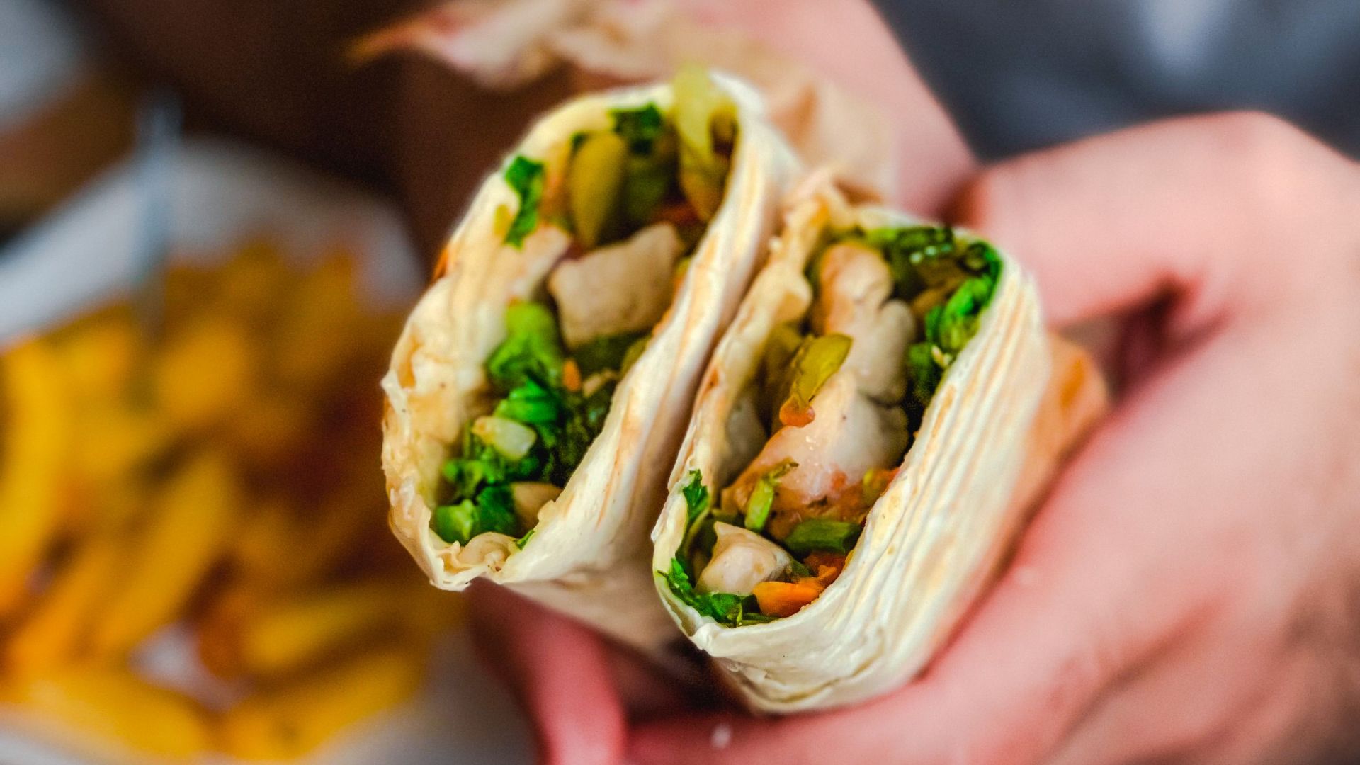 Close-up of a tasty chicken wrap filled with fresh vegetables, perfect for lunch.