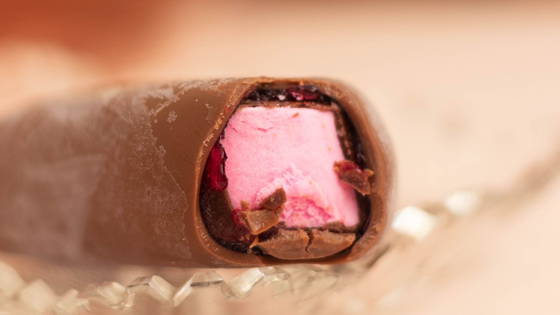 A delicious chocolate-covered marshmallow with pink filling on glass dish