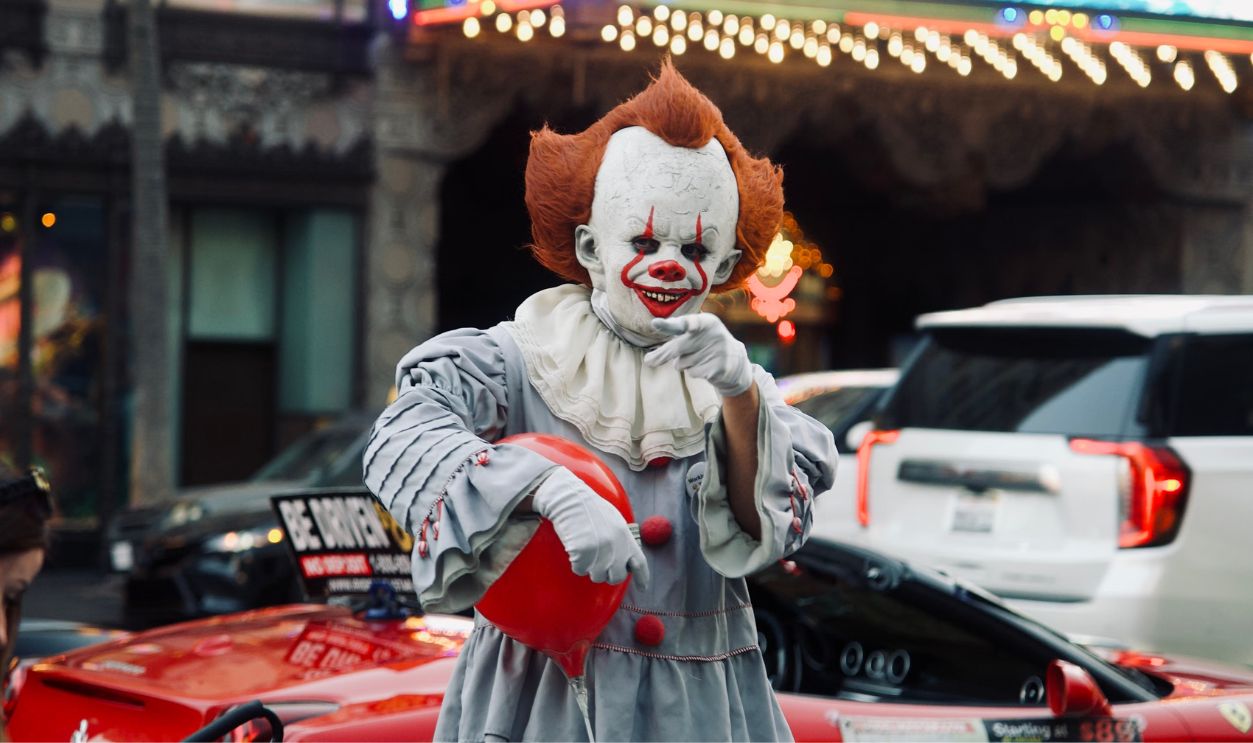 Clown in costume entertaining on Hollywood Boulevard with El Capitan Theatre in background