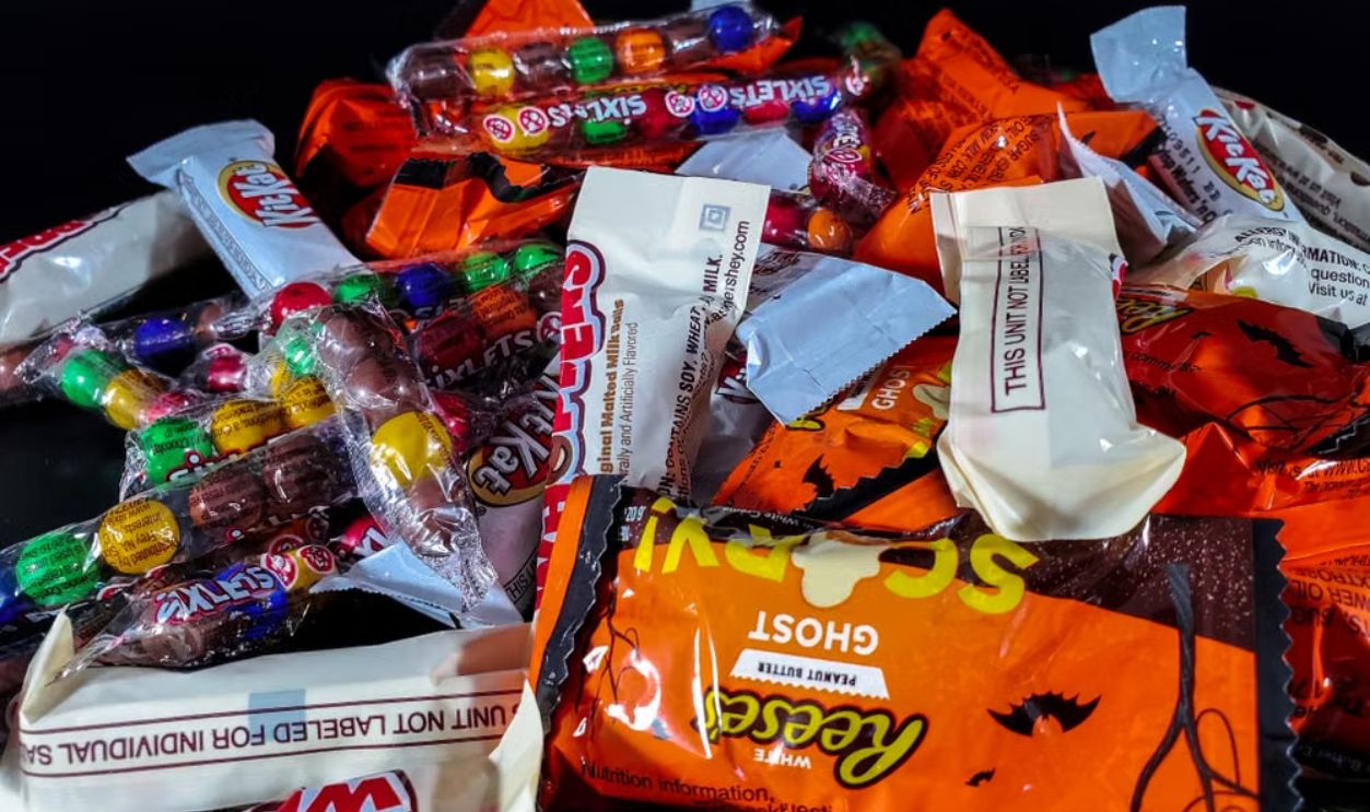 A vibrant stack of colorful Halloween candy wrappers showcasing a variety of sweet treats