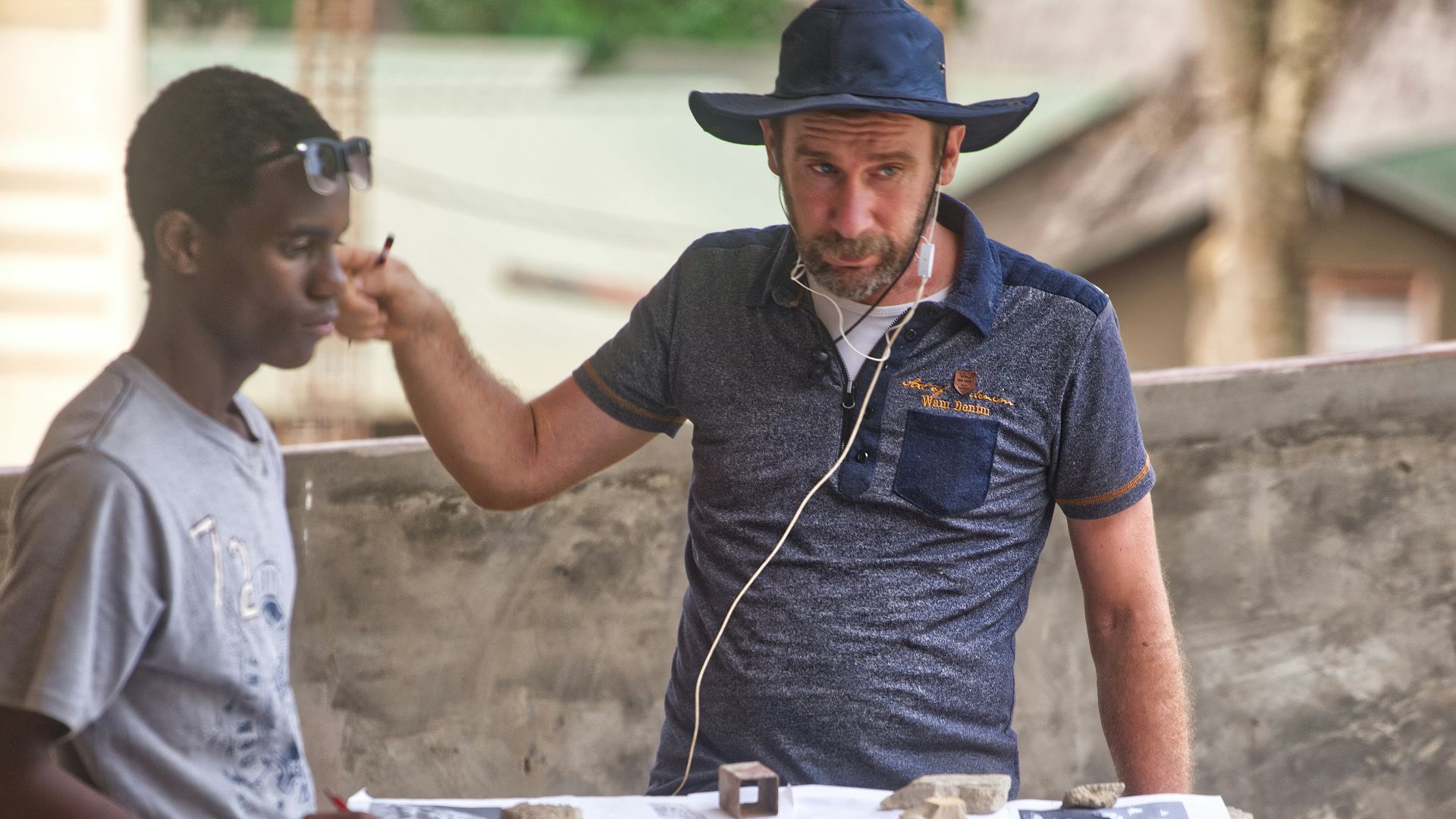 Two men examining artifacts on a table