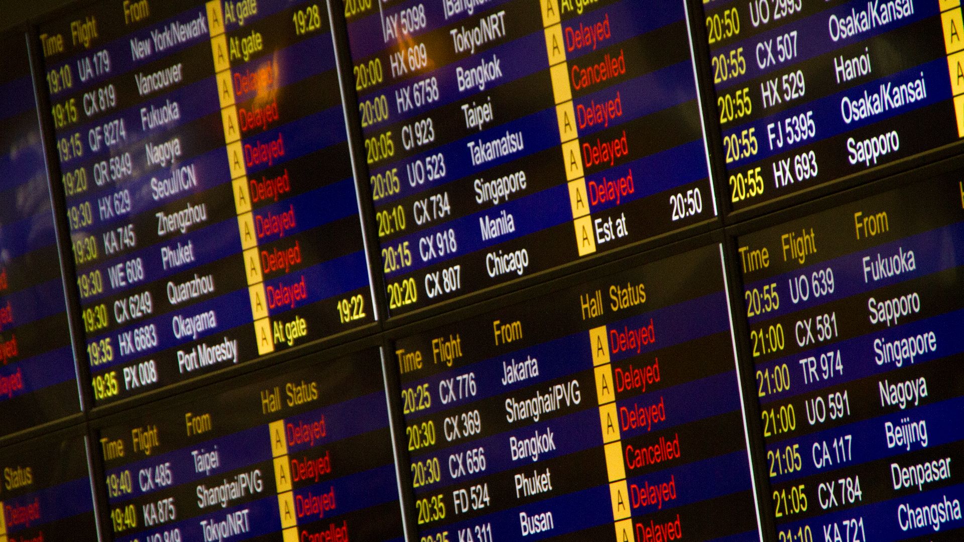 Close-up of digital flight information board showing arrivals and departures at an airport.