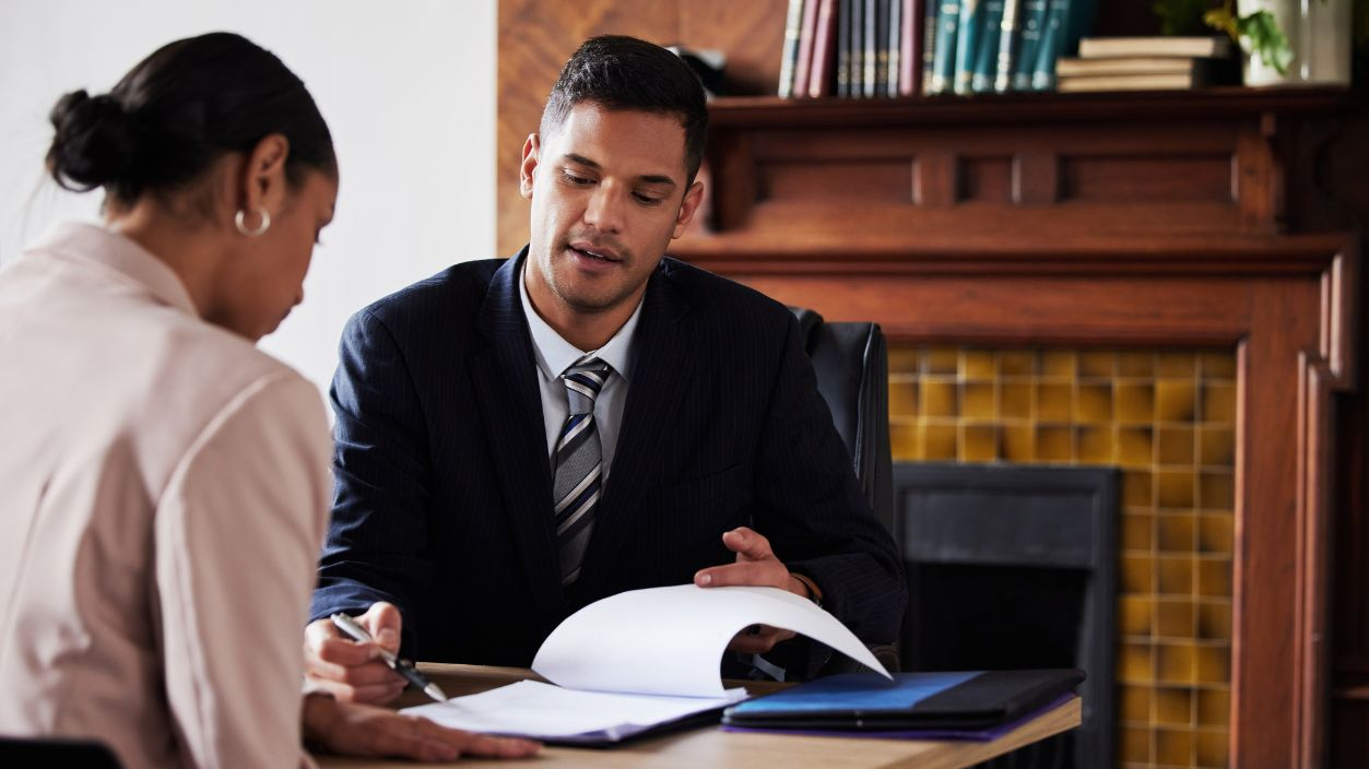 Shutterstock-2272166485, Contract, signing and lawyer consulting a client in his office with legal paperwork or agreement. Signature, approval and businessman in discussion with a woman with a document to sign in workplace.