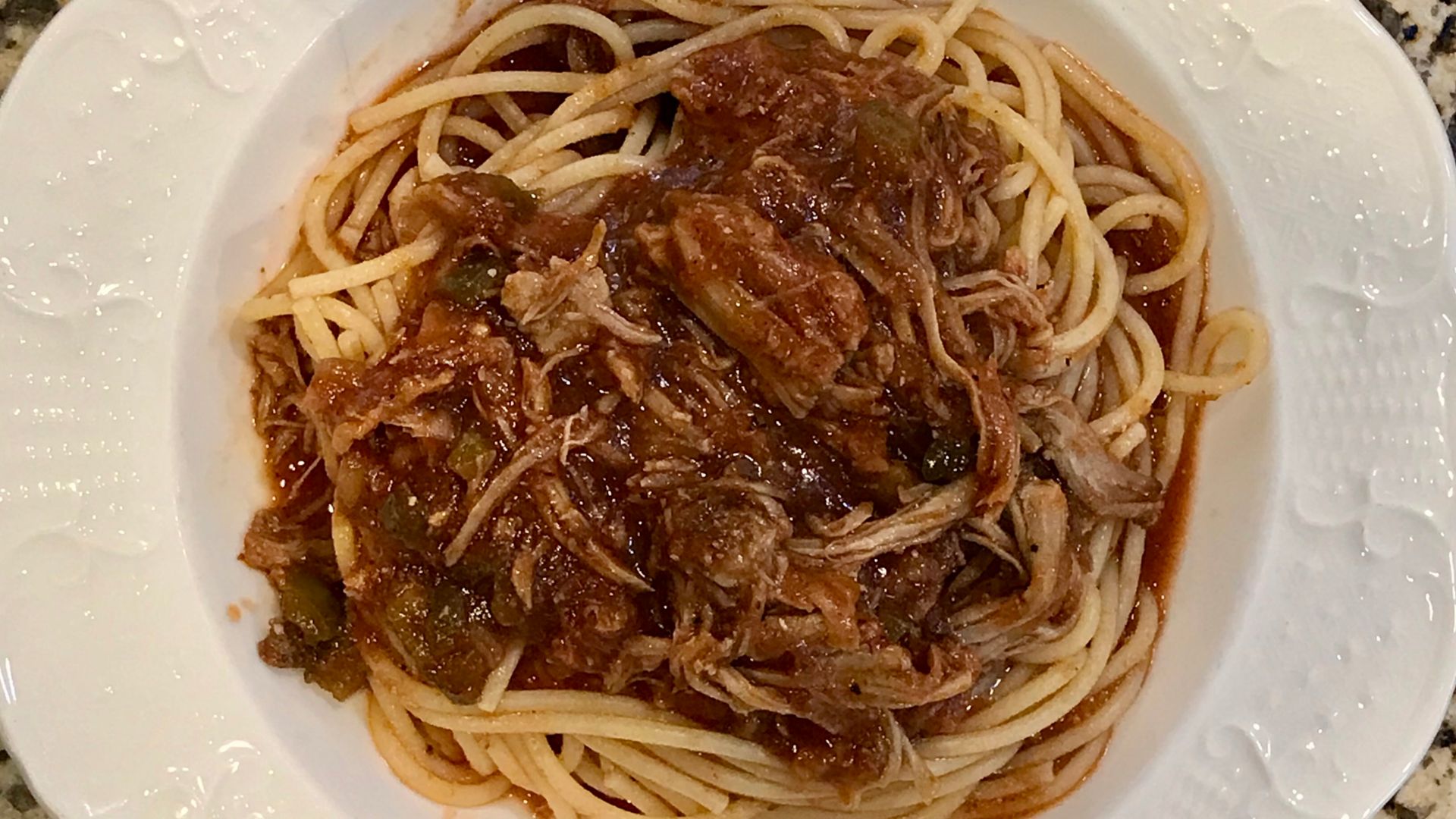 Spaghetti topped with pulled pork in a marinara sauce with a barbecue sauce base.