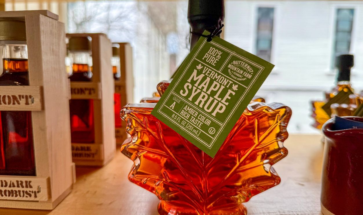 Johnson, VT - April 19, 2025: A bottle of Butternut Mountain Farm maple syrup in a glass maple leaf container captures the essence of Vermont's sweet harvest, perfect for any occasion
