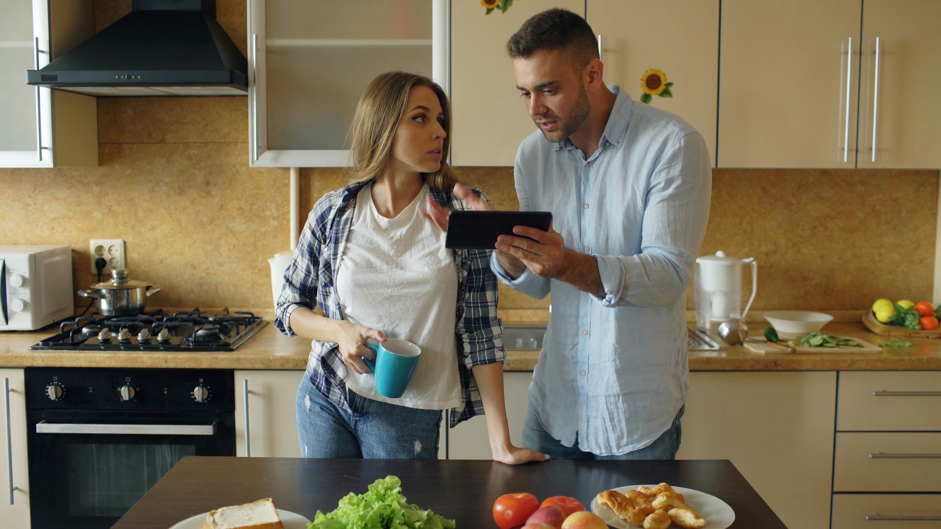 Couple looking at tablet in kitchen
