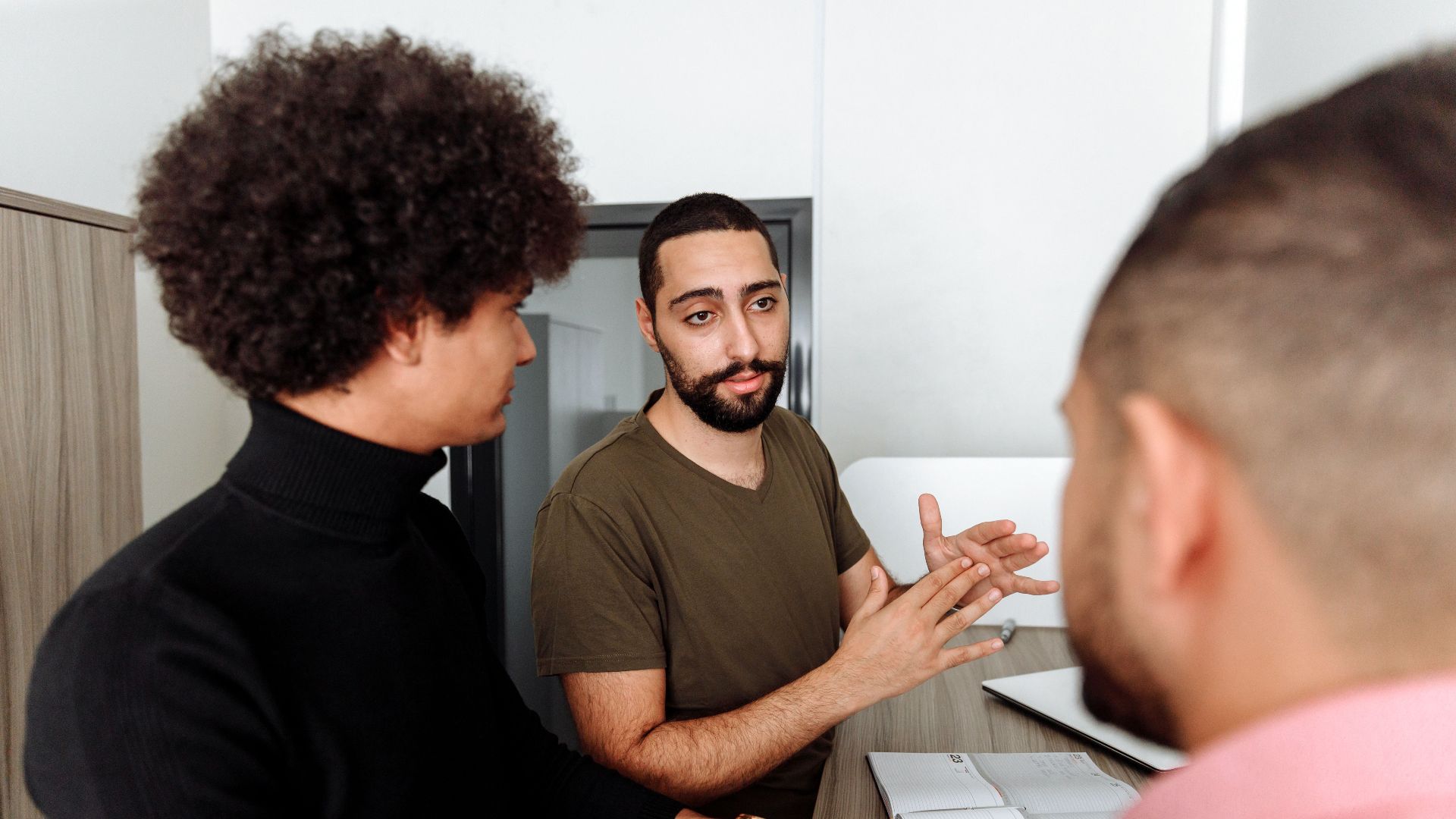 Group of colleagues having a thoughtful discussion in a modern office setting.
