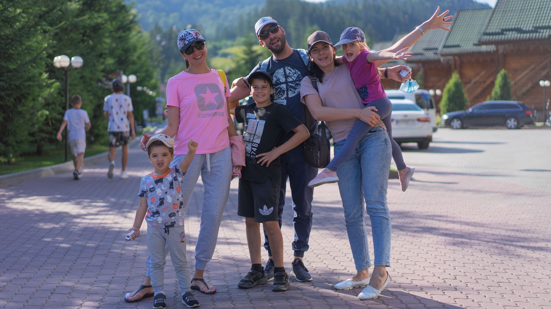 A joyful family of six spending quality time together in a scenic outdoor setting with mountains in the background.