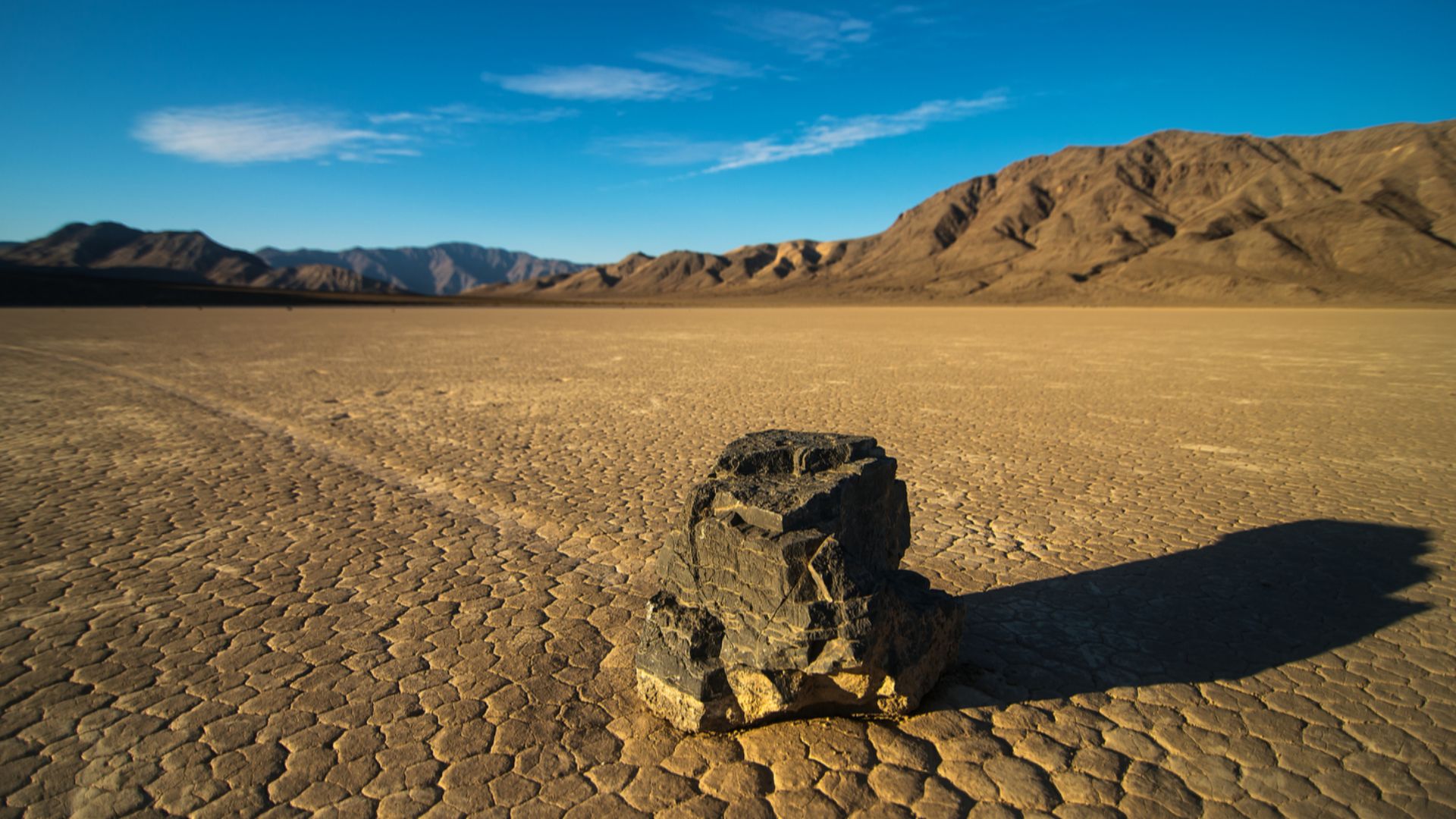 A stone traces a path across the dry lake bed of the Racetrack. This rare phenomenon of moving stones was recently documented when scientists documented breaking rafts of thin ice pushing stones as ice melted after winter rains.