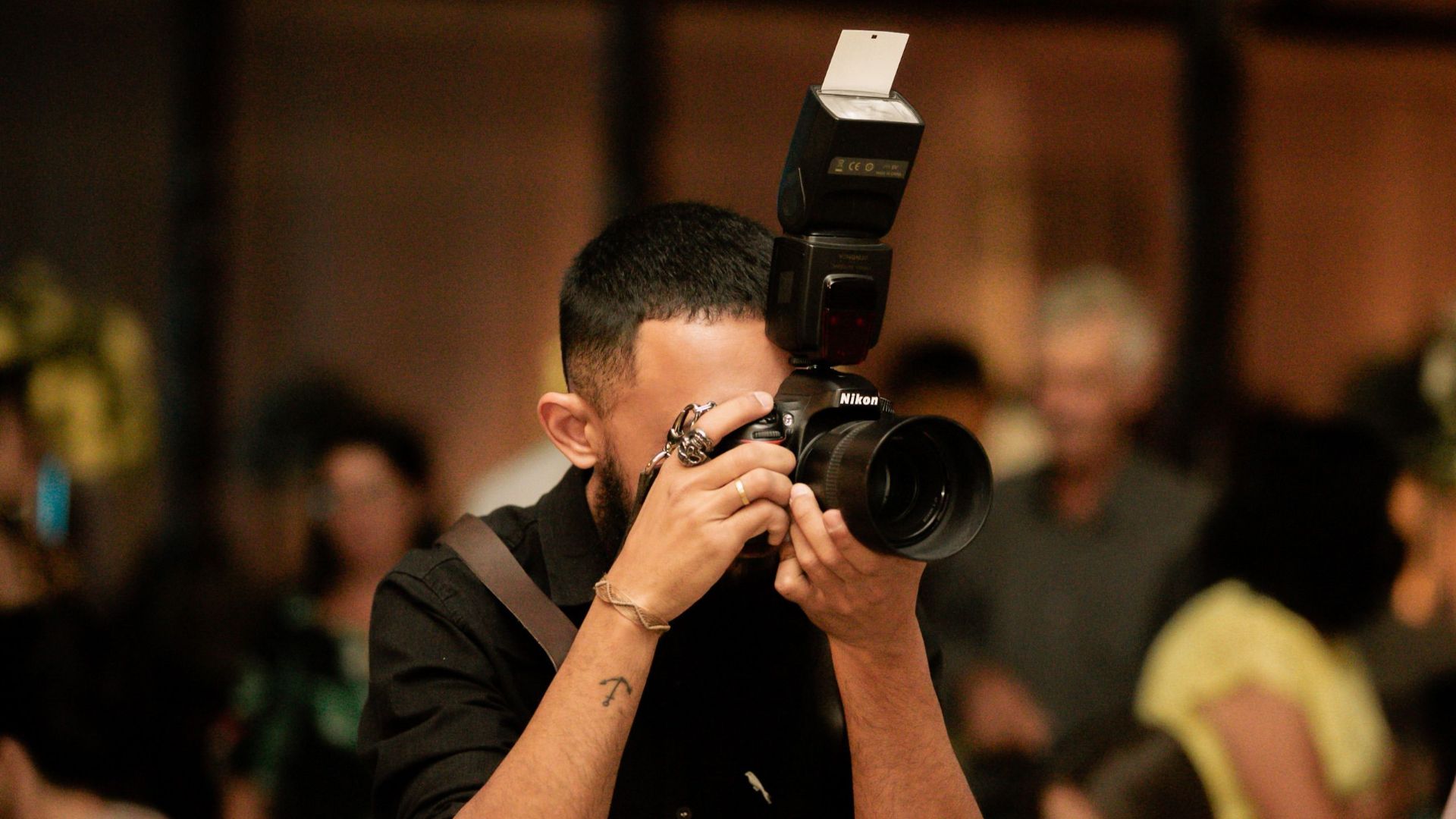A photographer captures moments at an indoor event in Alpinópolis, Brazil.