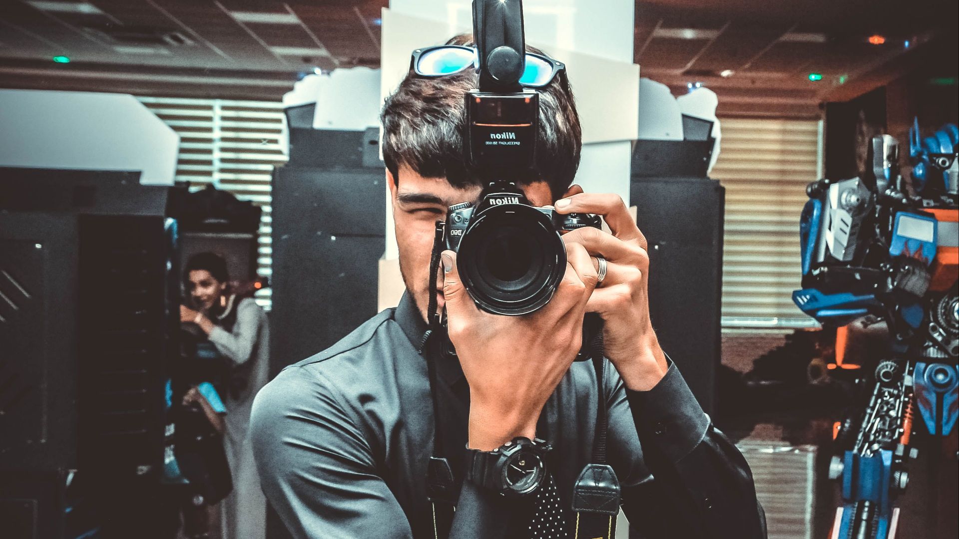 Man taking a picture with a DSLR camera indoors. Professional photography setup.