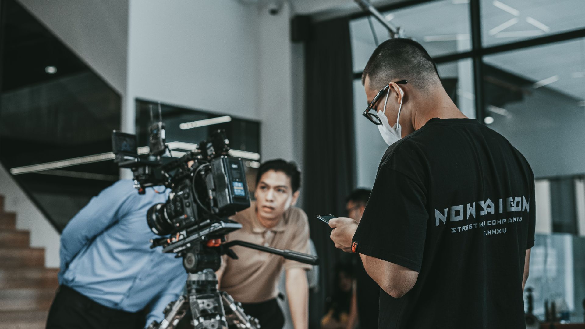 Camera crew working on a film set in Vietnam, capturing cinematic scenes indoors.