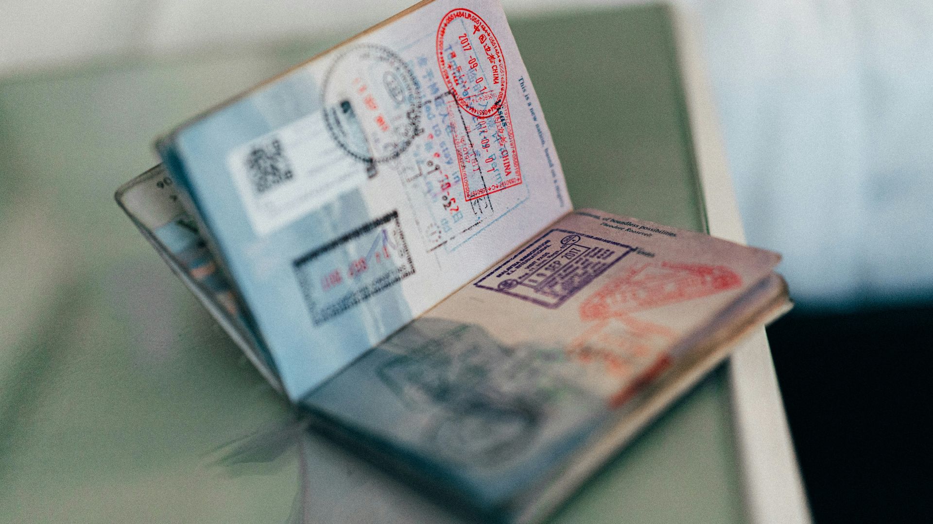 An open passport with multiple colorful ink stamps on the pages