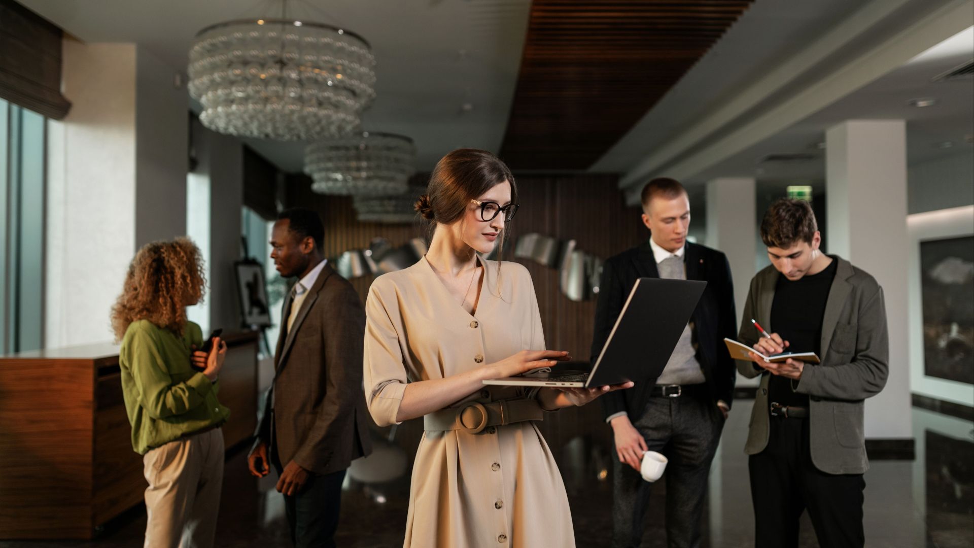 Group of business professionals in office having a discussion, using laptops and taking notes.