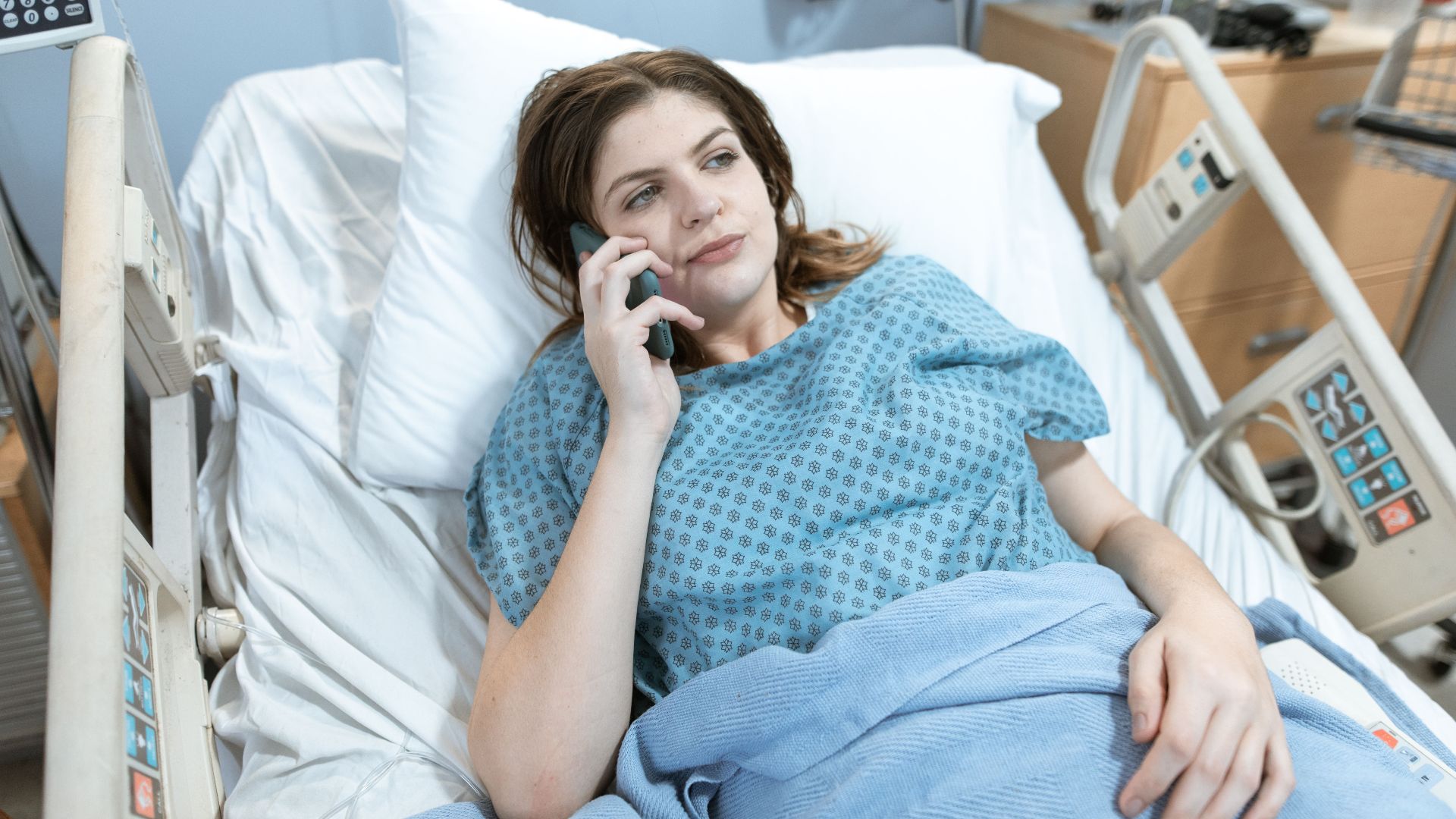 Woman in hospital bed talking on phone, representing healthcare and patient communication.