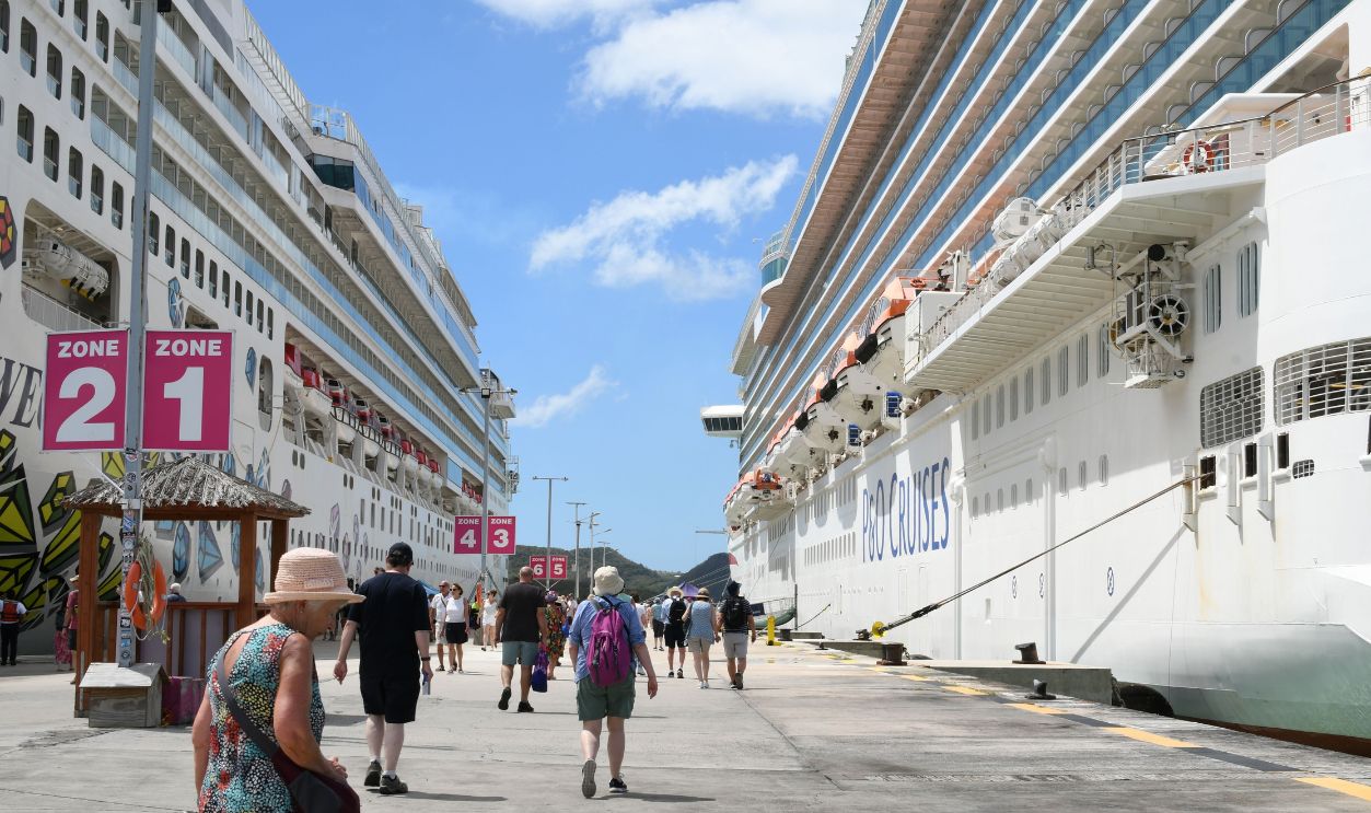 Bustling cruise port with tourists, featuring two large cruise ships