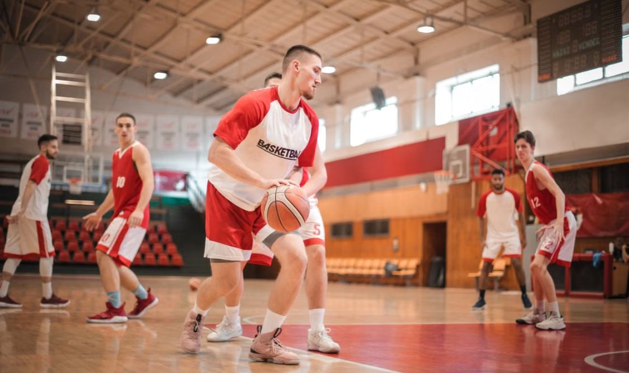 Male basketball players practicing on an indoor court, focusing on teamwork and athletic performance