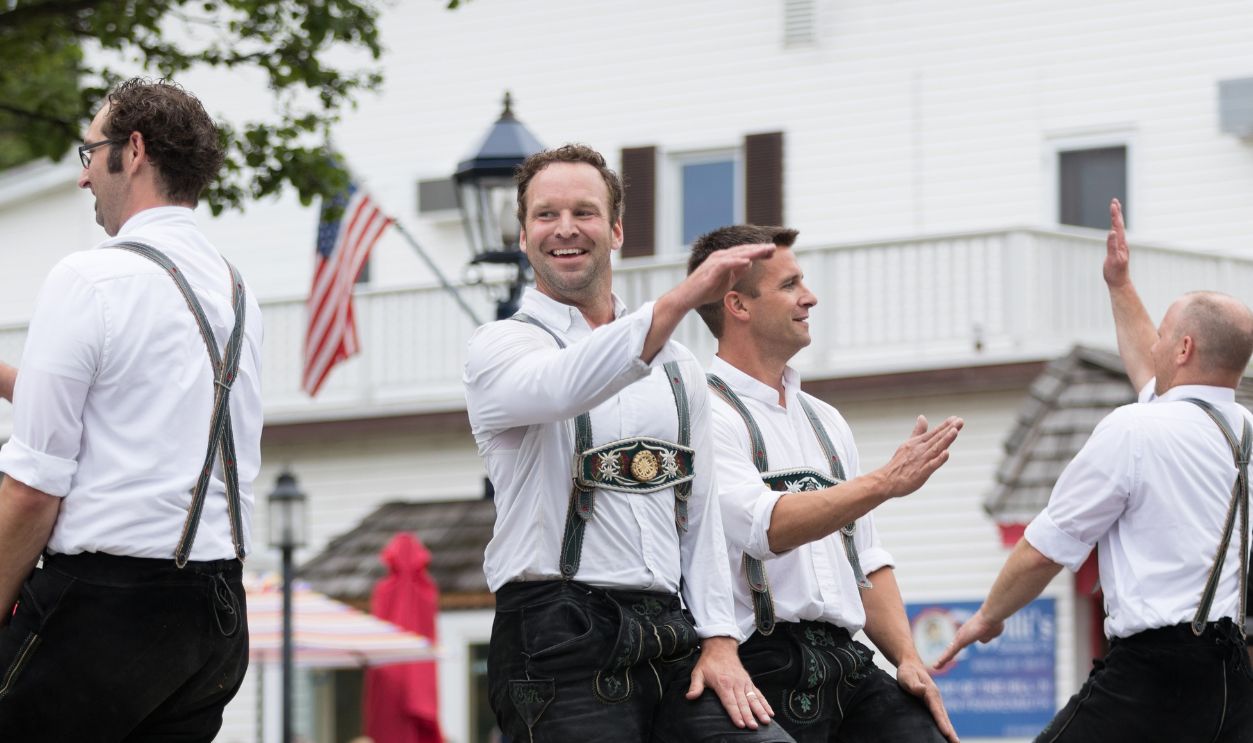 Frankenmuth, Michigan, USA - June 10, 2018 Men and women playing traditional german music drinking beer dancing and wearing traditional german clothing at the Bavarian Festival Parade.