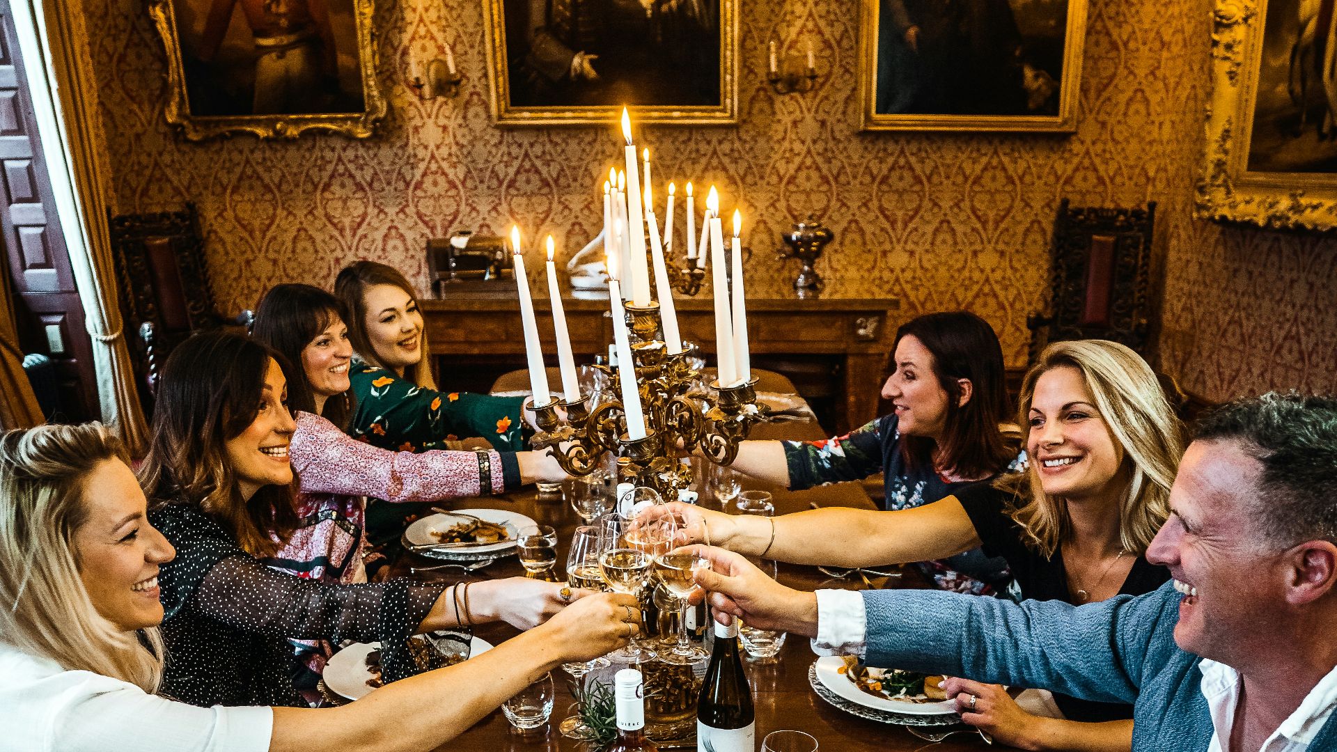 group of people sitting on chair in front of table with plates and drinking glasses