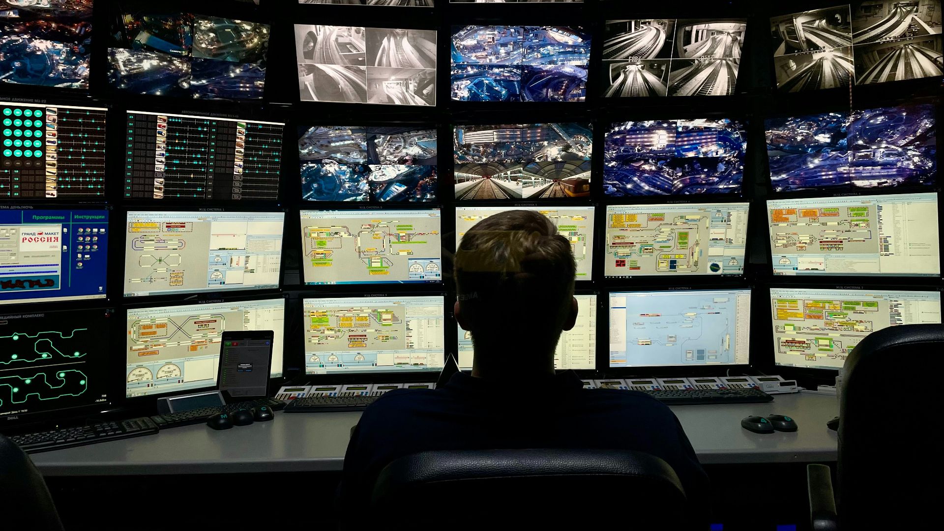 a man sitting in front of multiple monitors