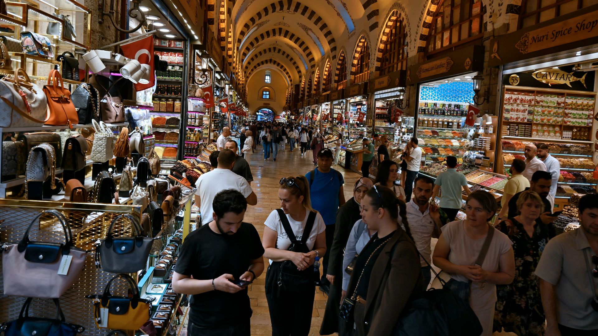 Crowded indoor market with arched ceilings and numerous vendor stalls