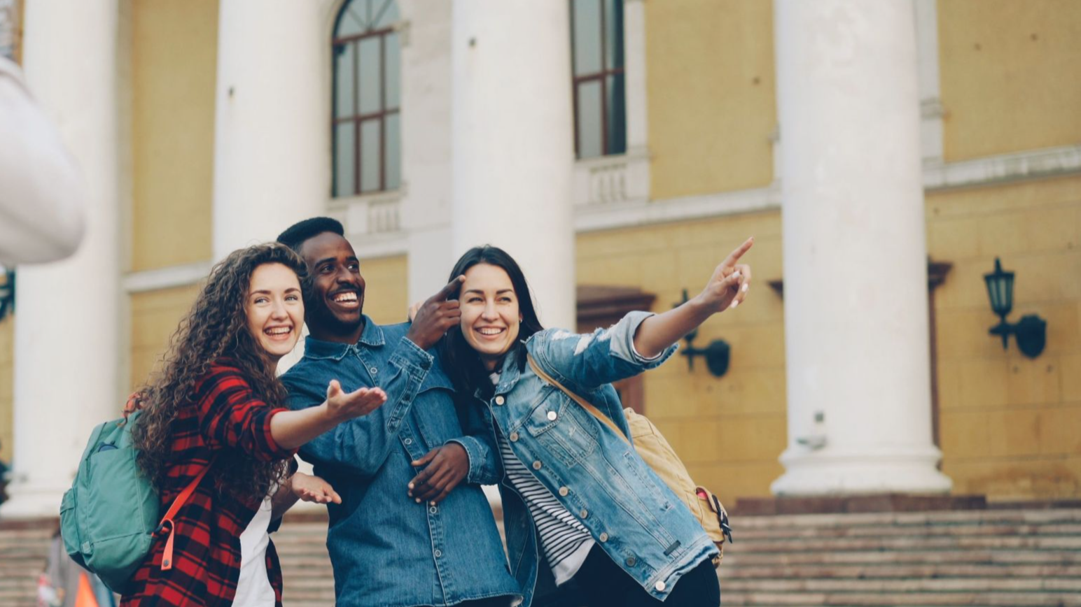 Three friends posing for a photo near a historic building with columns.