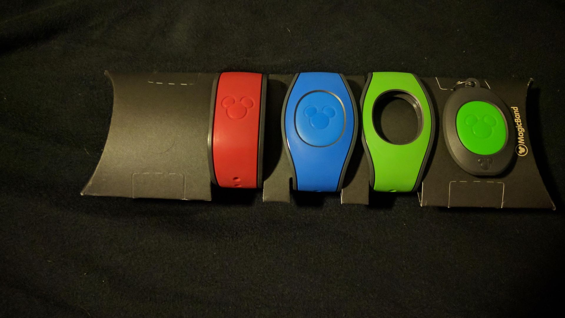 From left to right: Red (original) MagicBand, Blue MagicBand 2 with Icon, Green MagicBand 2 without Icon, MagicKeeper with Green Icon. Screwdriver that comes with MagicKeeper is also pictured.

Note: Name to the left of the Blue MagicBand 2 has been edite