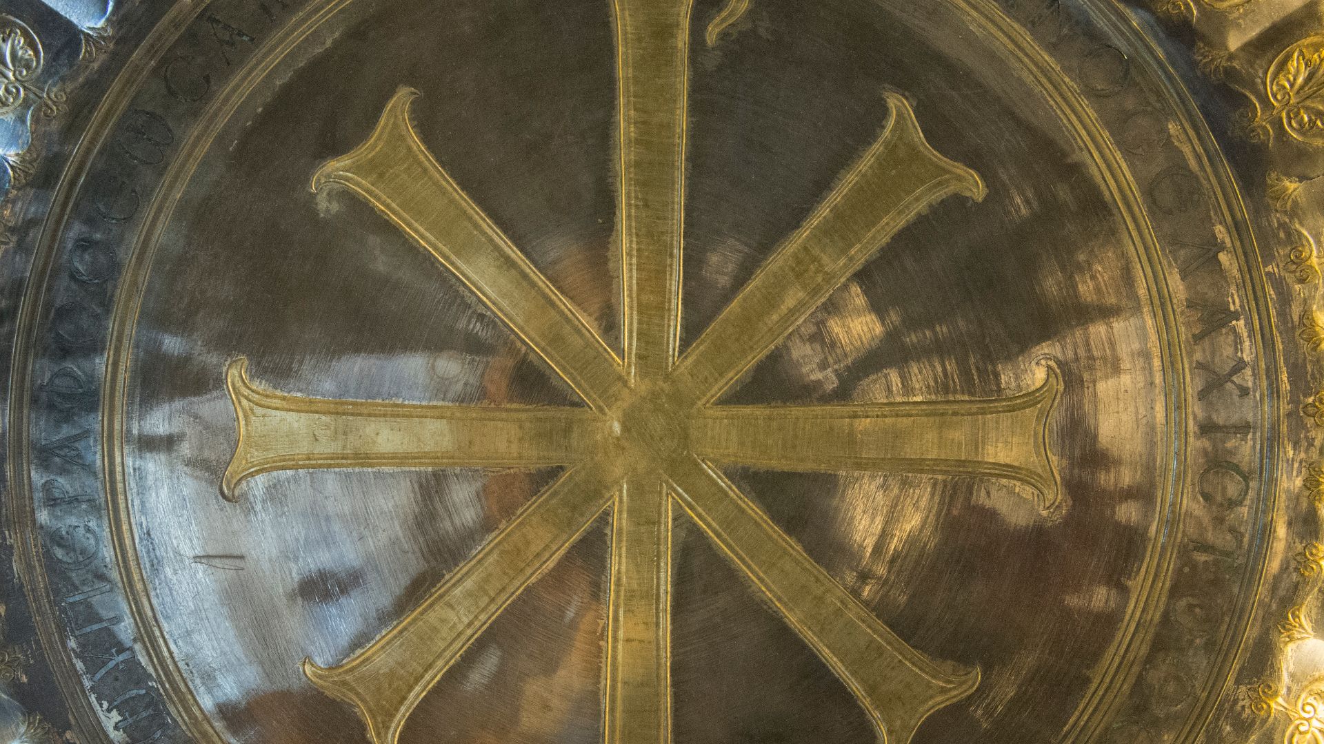 Silver Gilt with niello decoration D: 47cm. Byzantine Period, 6th century A.D. Korydalla (Kumluca) - A.1020
A decorated flat tray with a ring base and marked with four control stamps. In the centre there is a large chrismon symbol encircled by an engraved