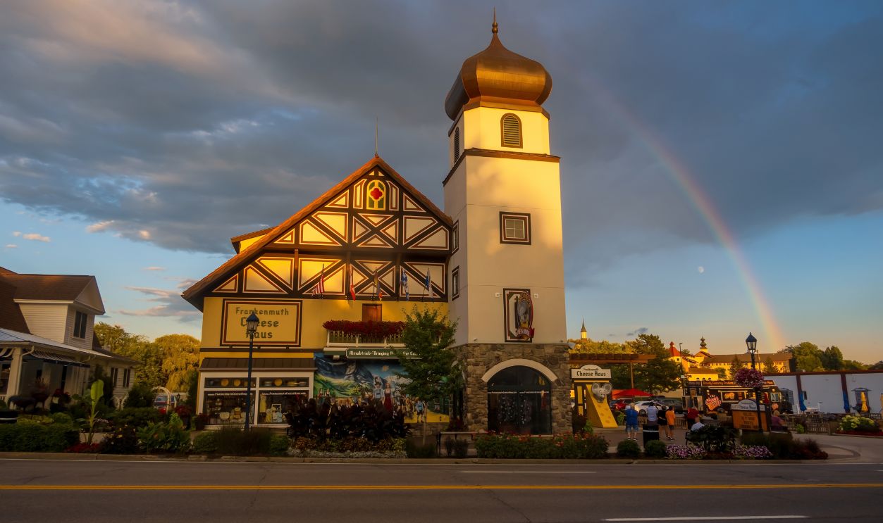 Frankenmuth, MICHIGAN, USA -JULY 29, 2023: Historic Frankenmuth Cheese Haus building with colorful rainbow on a partly cloudy day in Frankenmuth, Michigan.