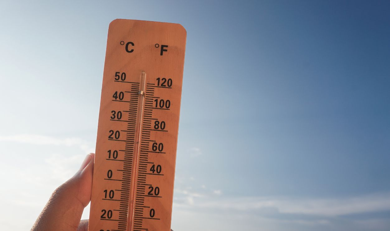 Celsius and fahrenheit scale thermometer shows plus 30 degrees during midday in Asia with sky background. The thermometer shows temperatures above 30 degrees in summer
