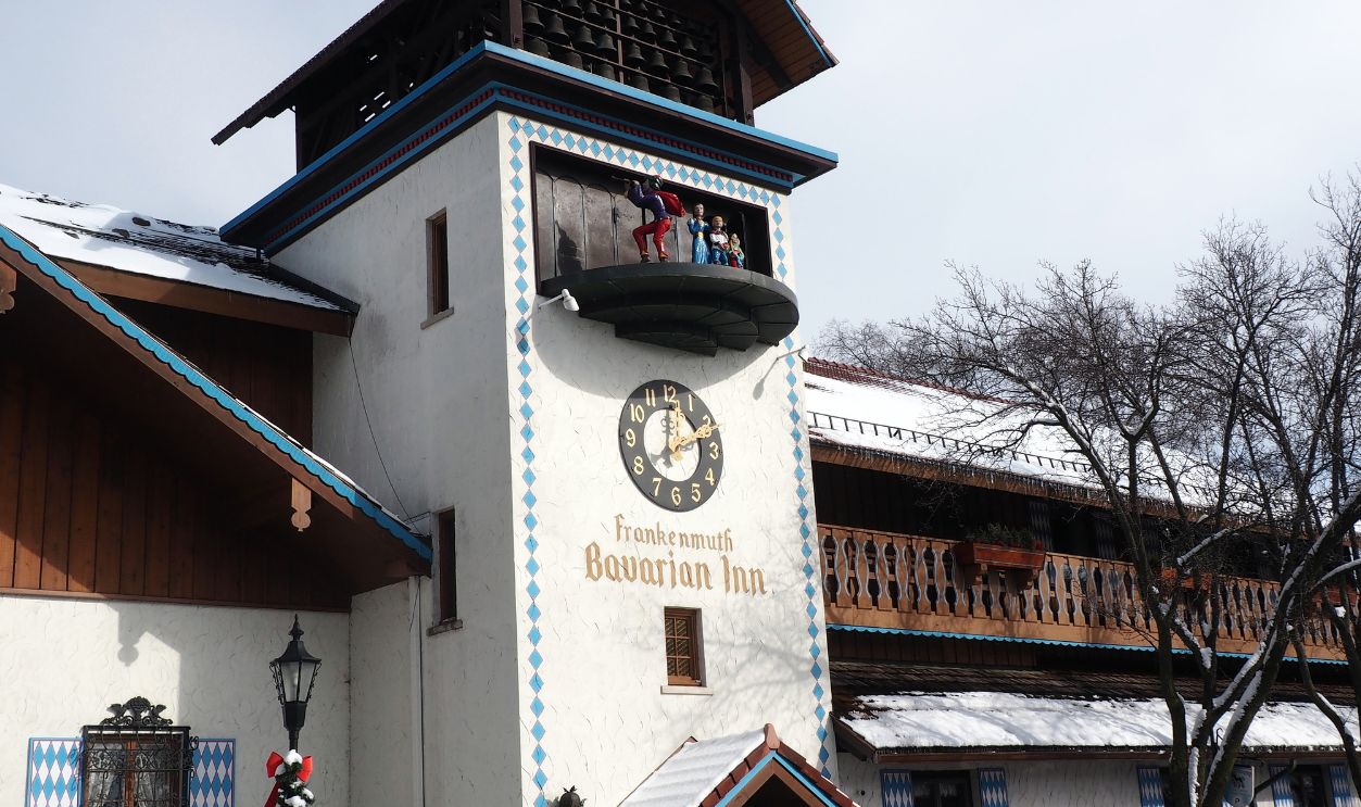 Frankenmuth, Michigan, USA - February, 07, 2019: Bavarian Inn glockenspiel in the town center. Bavarian style white and blue building with tower with moving clock and figurines. Taken around midday.