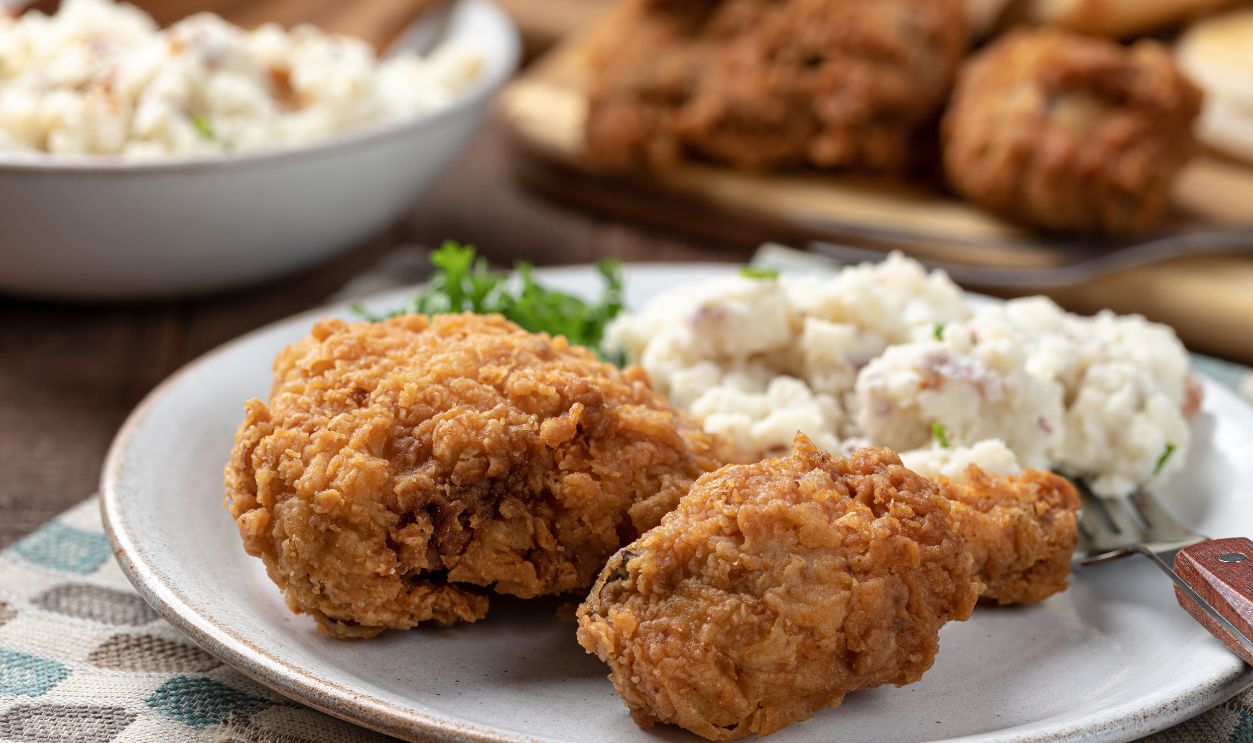 Crispy fried chicken leg and thigh dinner with mashed potatoes on a plate